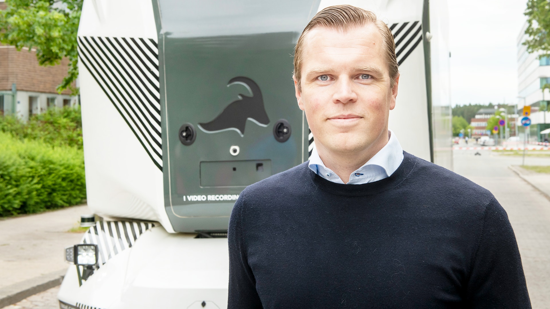 Man som står framför ett autonomt fordon