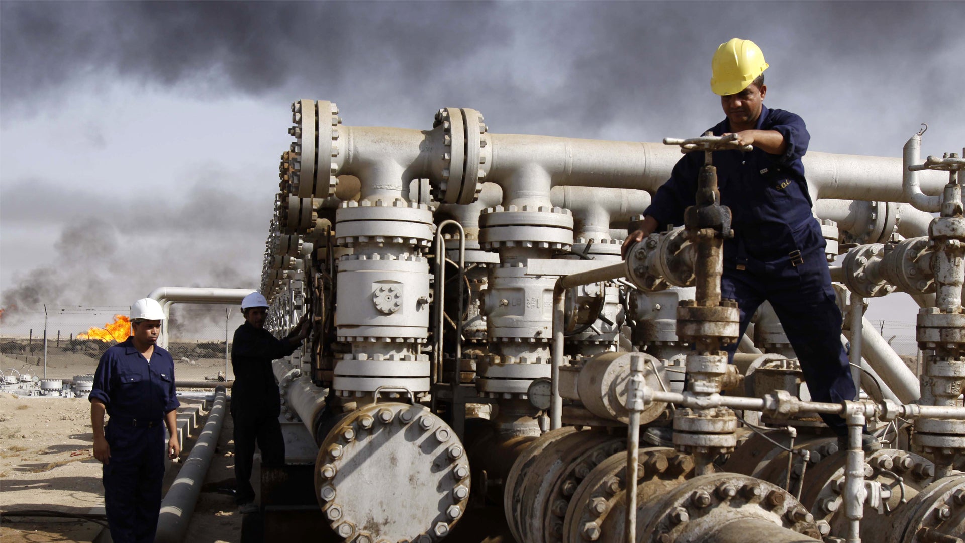 Arbetare inspekterar stor industriell rörledningsanläggning på en oljeraffinaderi eller gasanläggning.