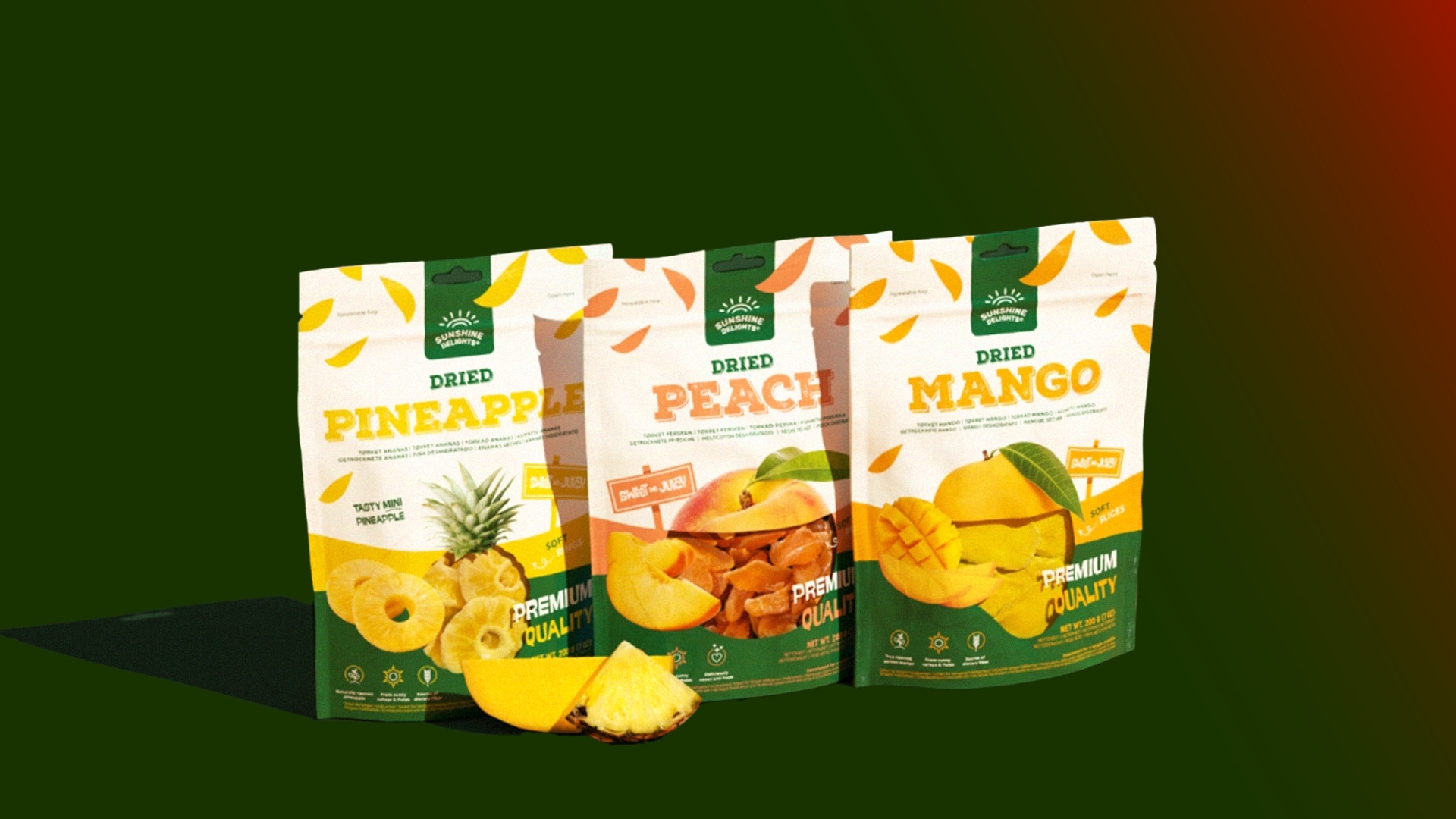 Tre förpackningar med torkad frukt: ananas, persika och mango, tillsammans med lösa fruktstycken framför förpackningarna.