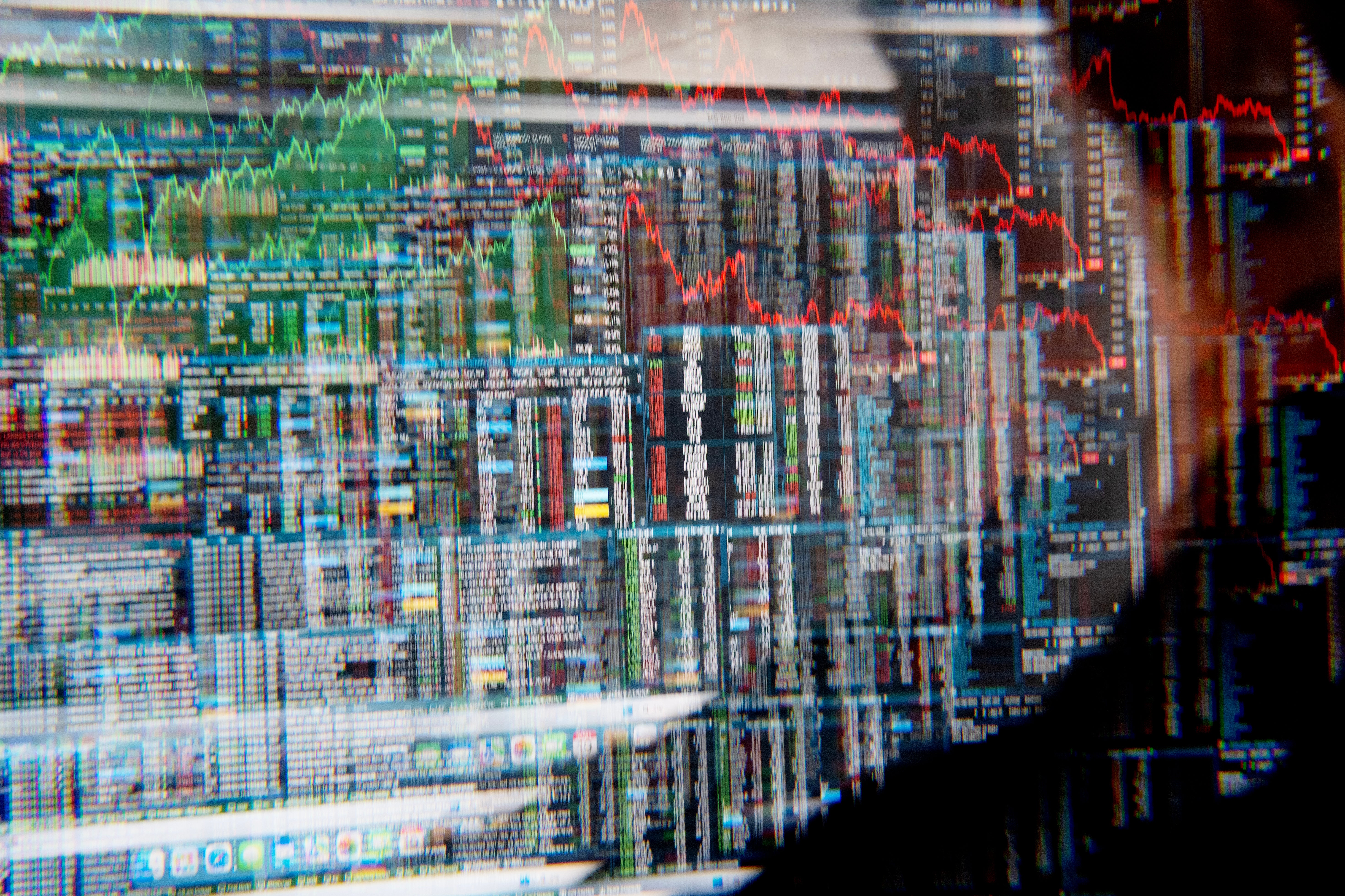 Finansiella marknadsgrafer med gröna och röda trendlinjer som visar aktiekursrörelser och marknadsdata.