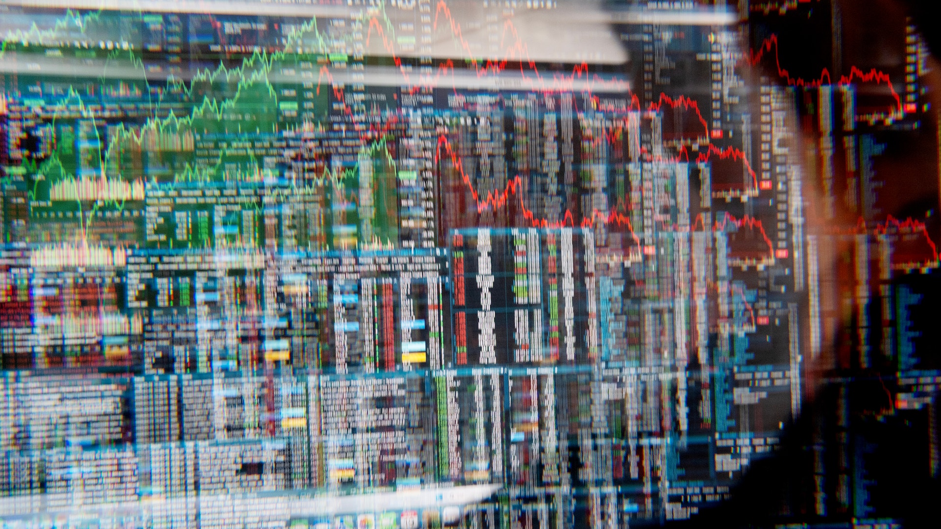 Finansiella marknadsgrafer med gröna och röda trendlinjer som visar aktiekursrörelser och marknadsdata.