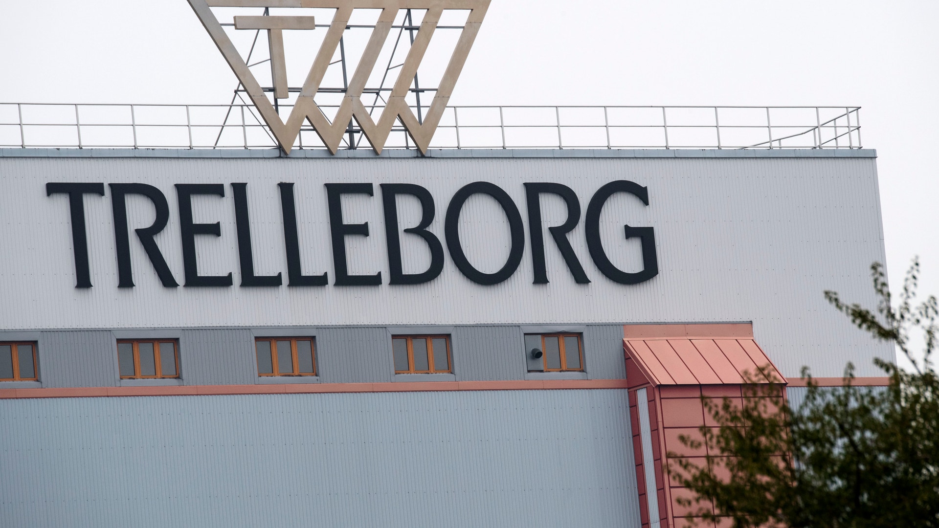 Industribyggnad med Trelleborgs logotyp på fasaden och en basketkorg på taket.