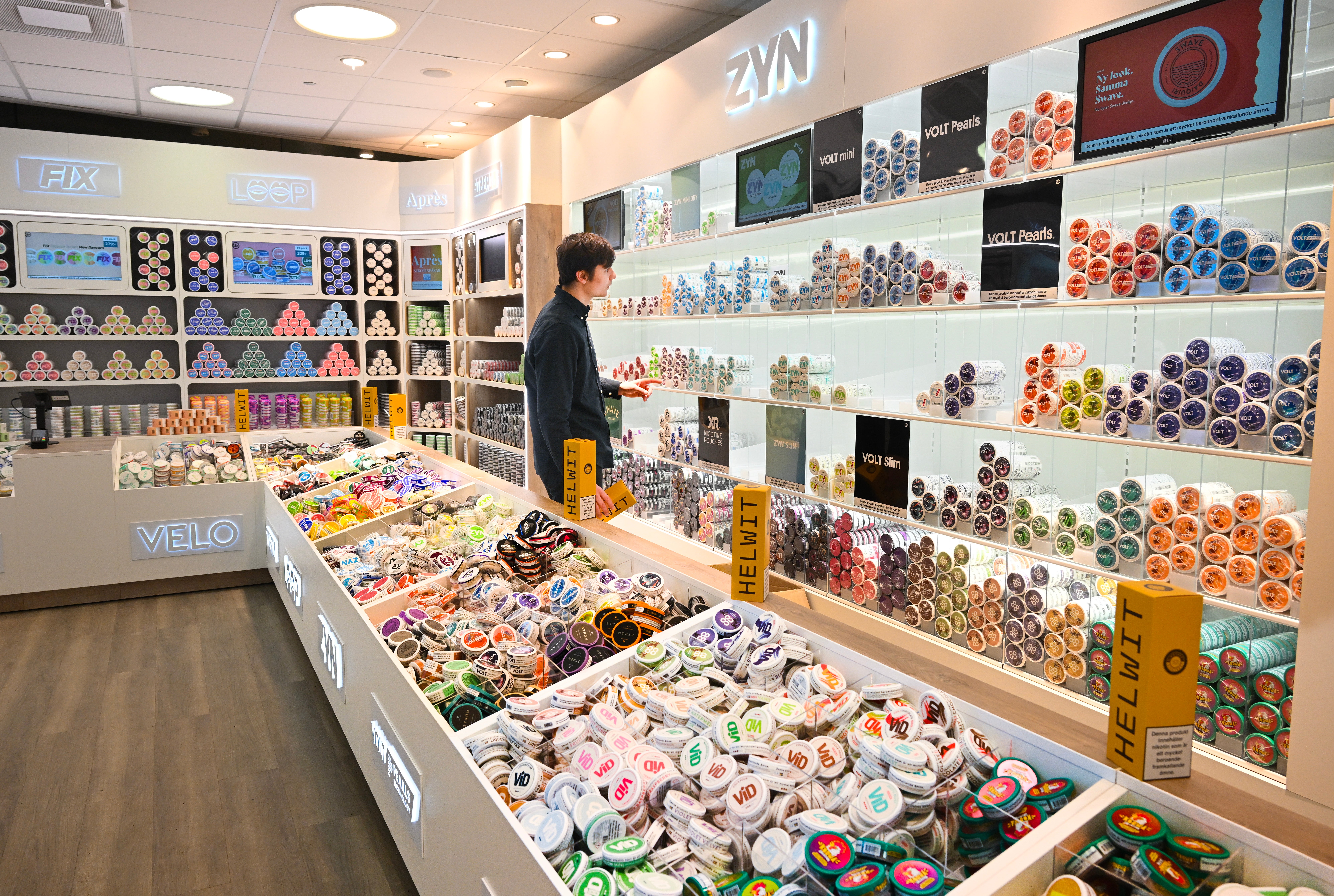 En butik med väggmonterade hyllor och en försäljningsdisk fylld med färgglada dekorativa tejper och tillbehör.