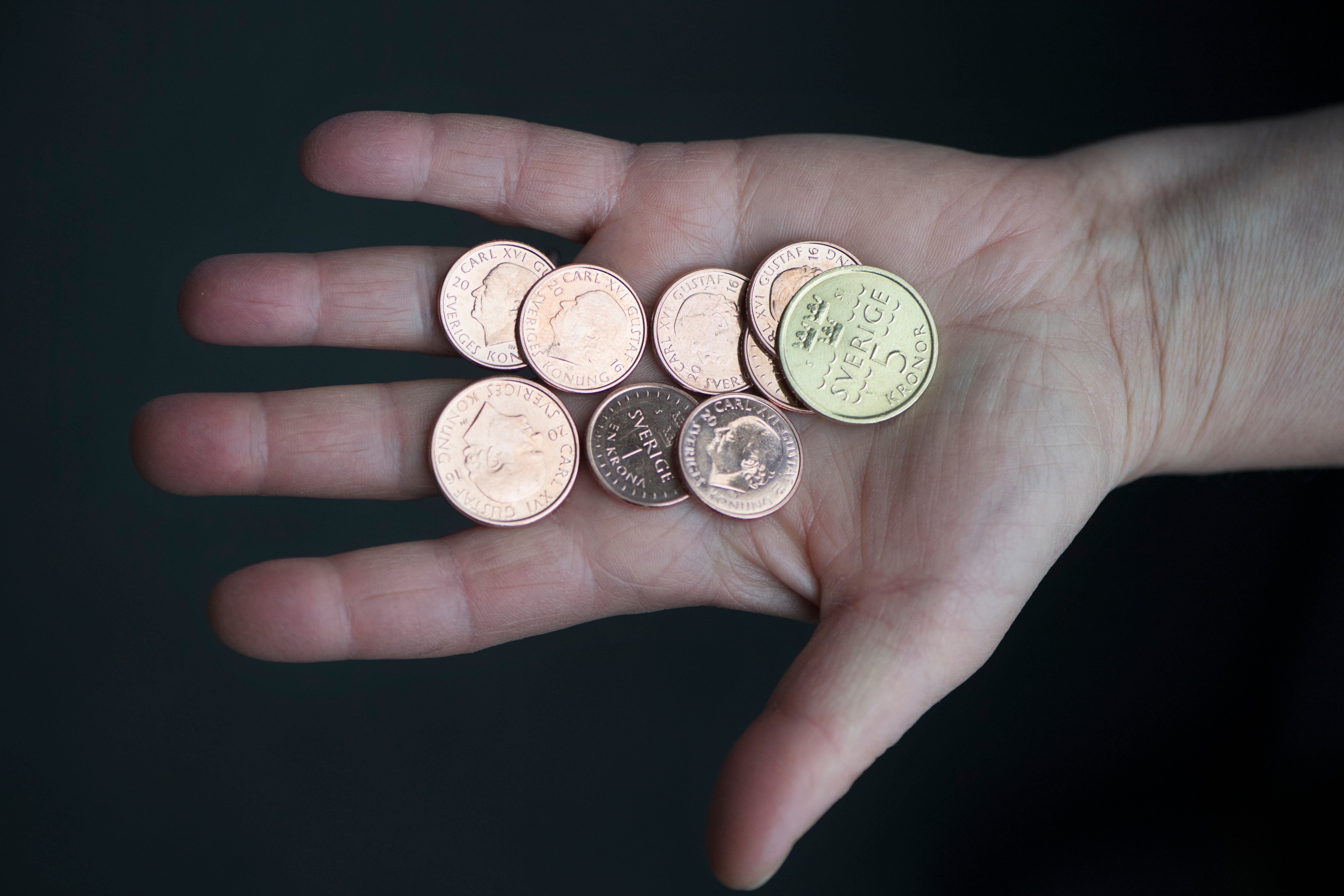 En hand som håller flera mynt