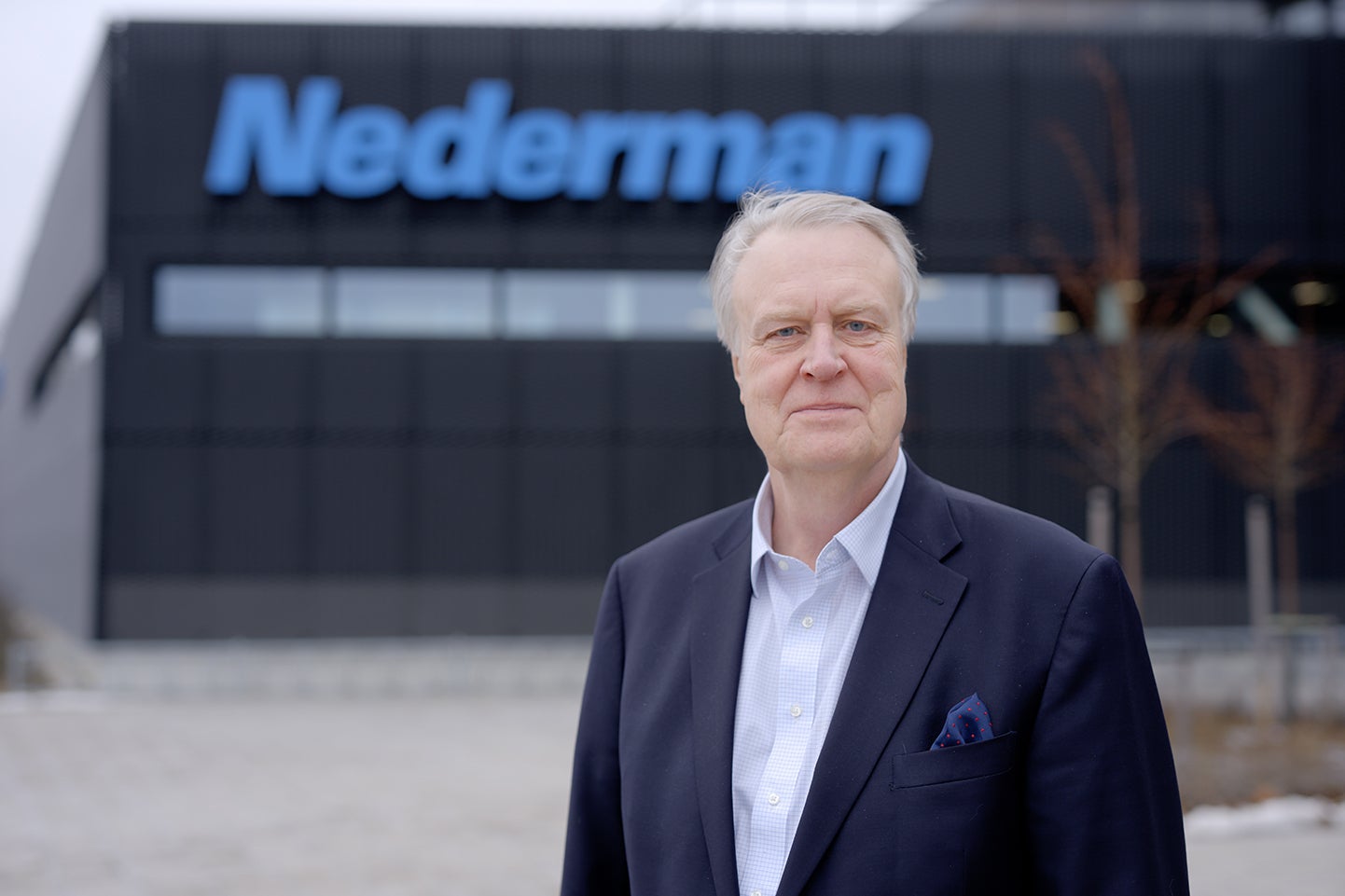 Porträtt av en man i kostym framför Nedermans huvudkontor