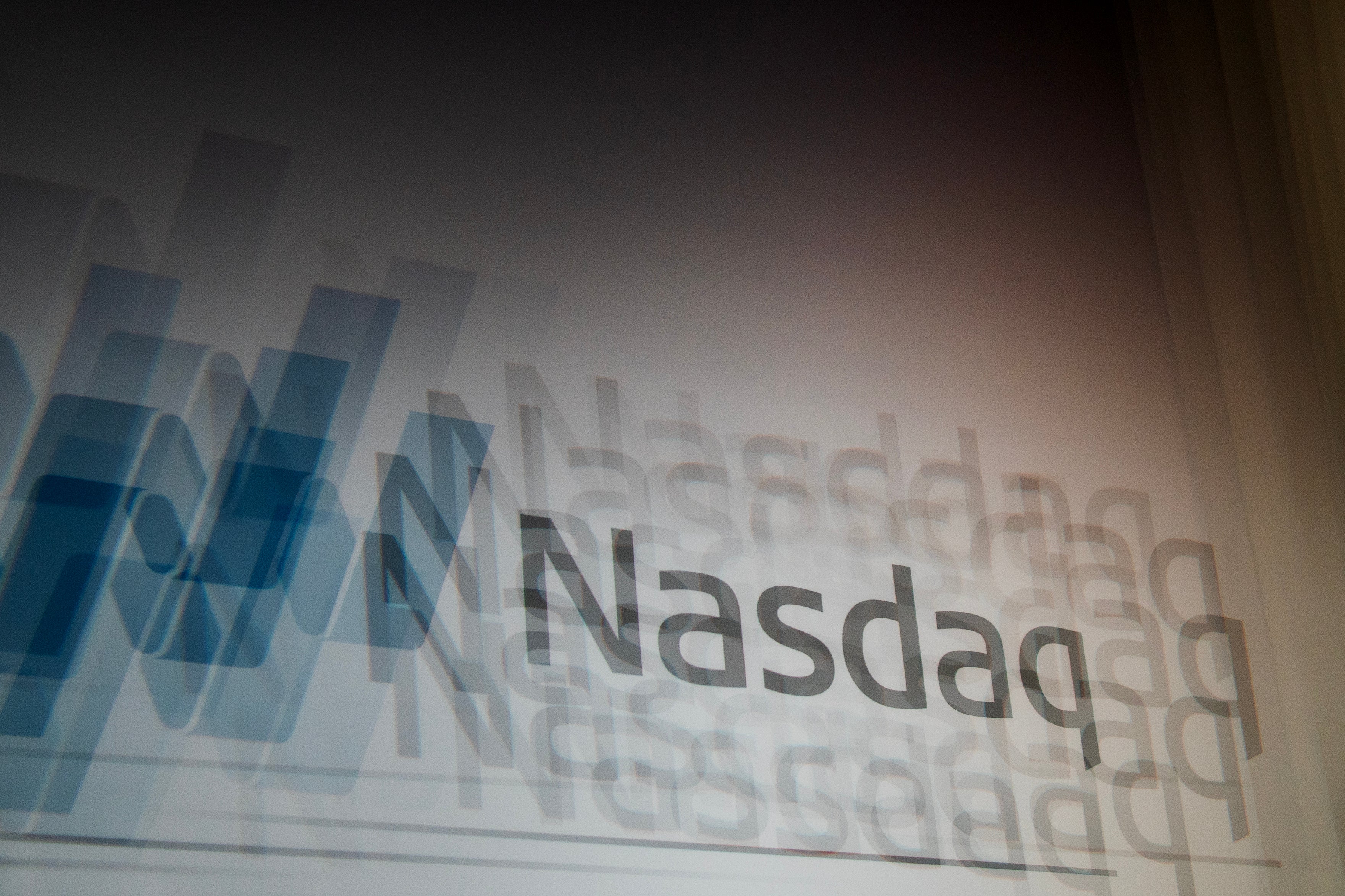 Nasdaq-logotyp med blå och vita geometriska former i bakgrunden.
