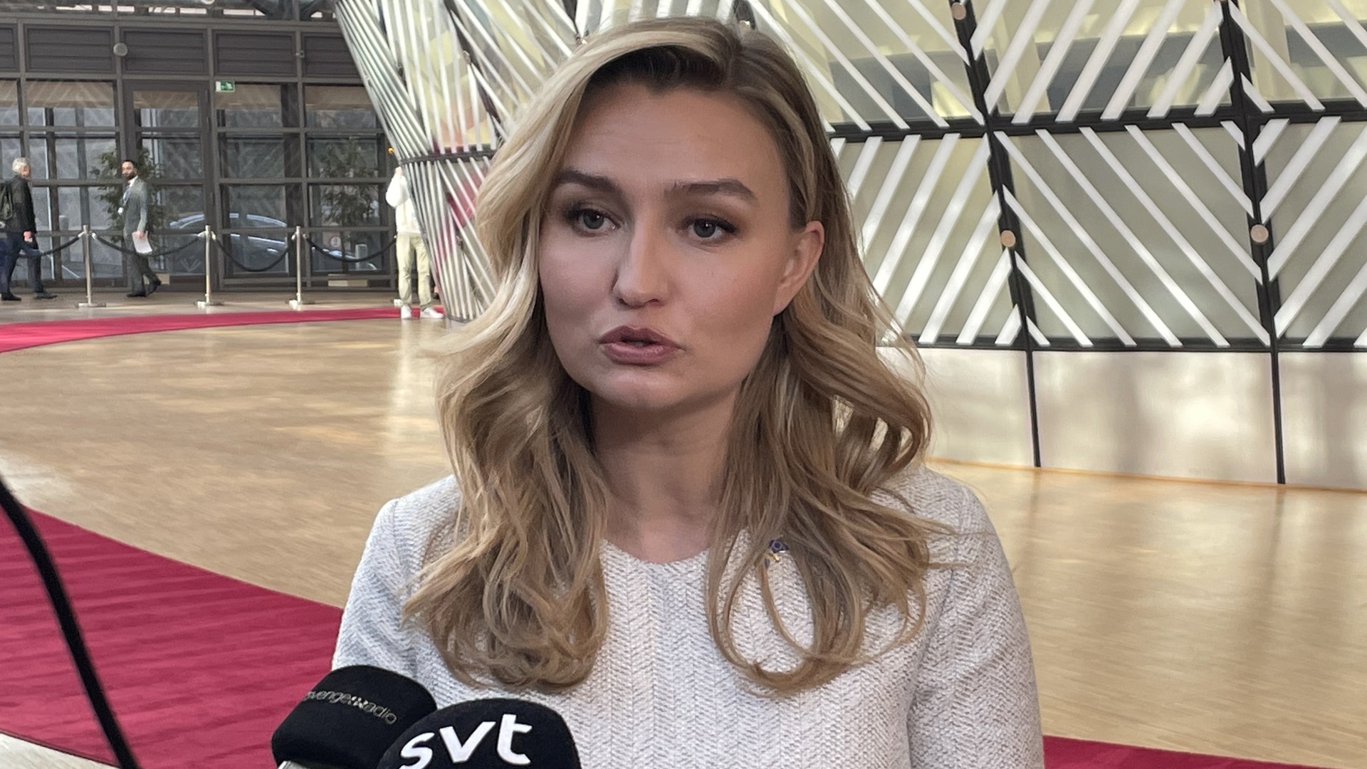 Kvinna intervjuas med mikrofon i en modern inomhusmiljö