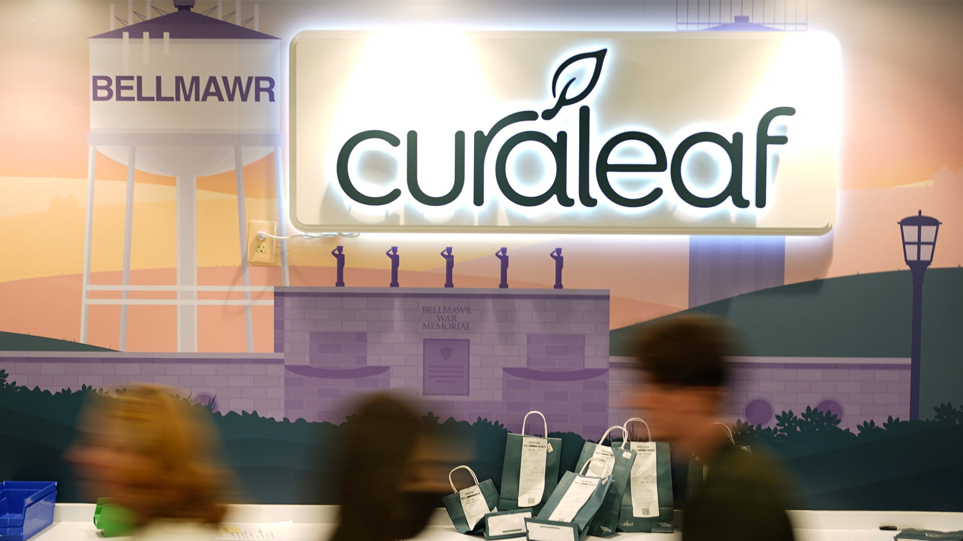 Curaleaf-butik med neonskyltar och människor som handlar