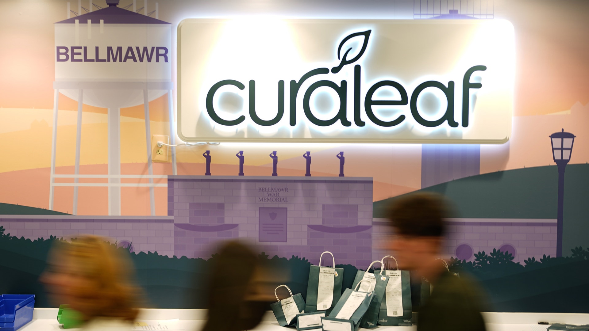 Curaleaf-butik med neonskyltar och människor som handlar