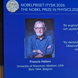 Skärm som visar Nobelpriset i fysik 2026 med ett porträtt av pristagaren Francis Halzen, en äldre man med glasögon och korslagda armar.