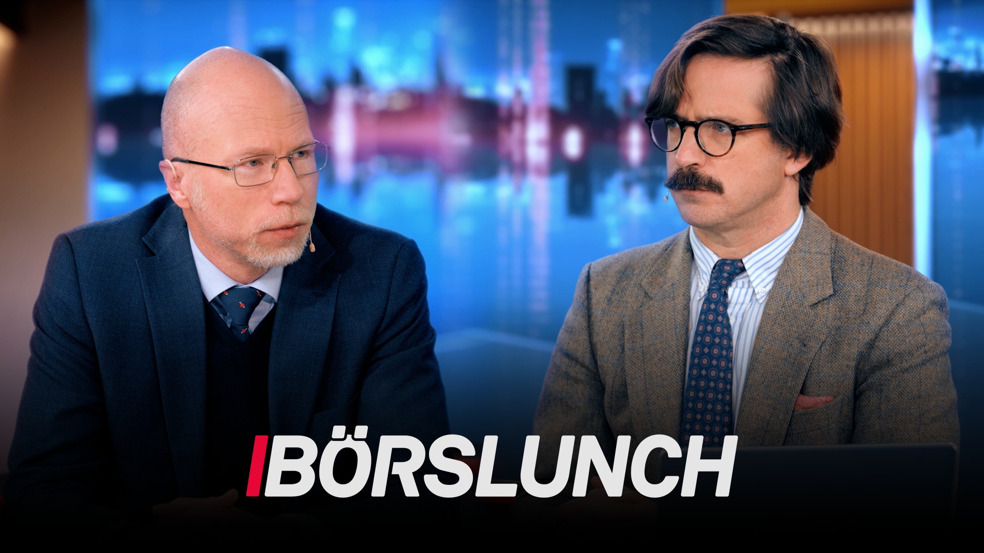 Två män i kavajer sitter bredvid varandra i en tv-studio. Nederst i bilden syns programlogotypen Börslunch.