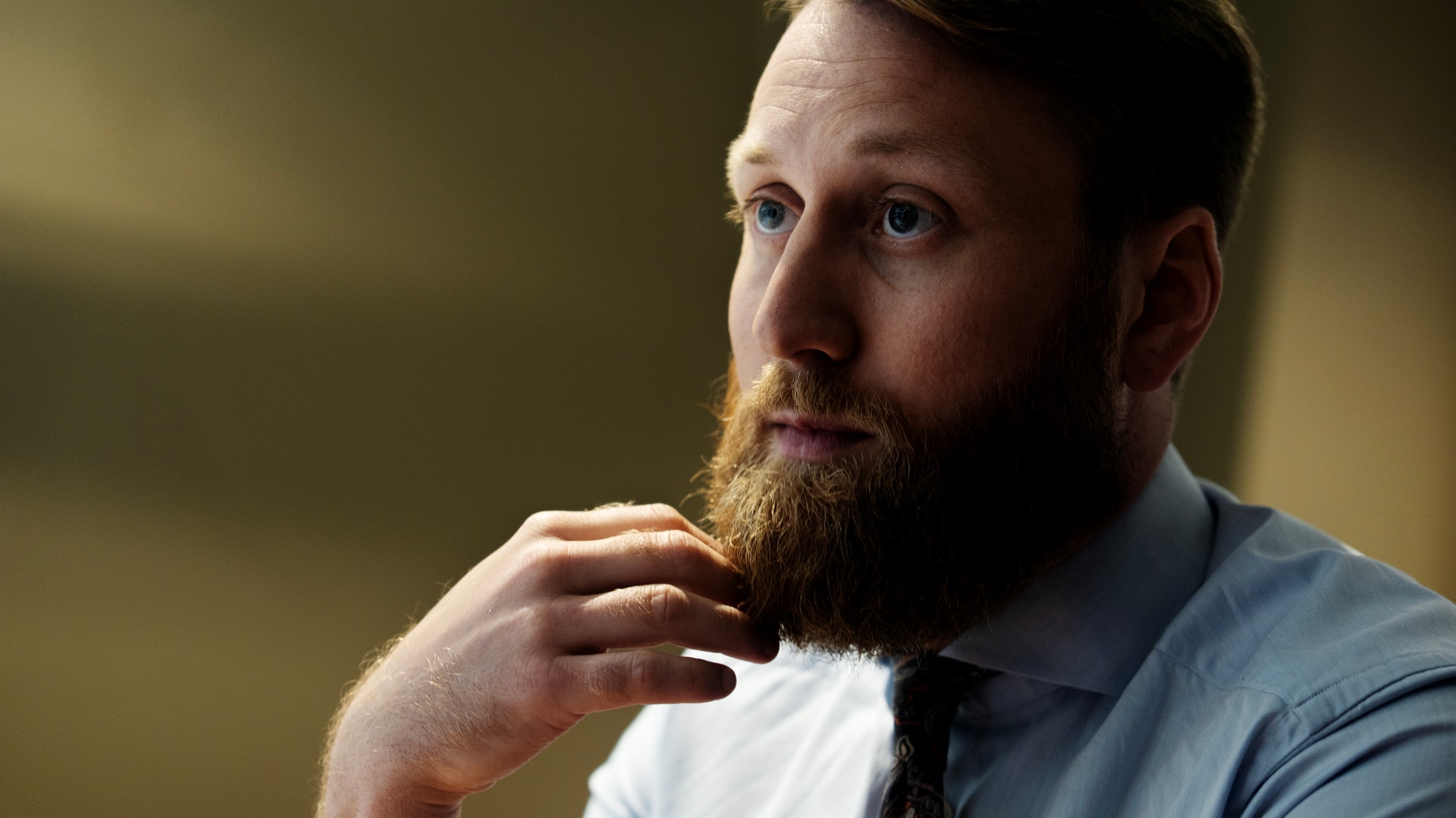 Porträtt av en man med skägg i professionell miljö