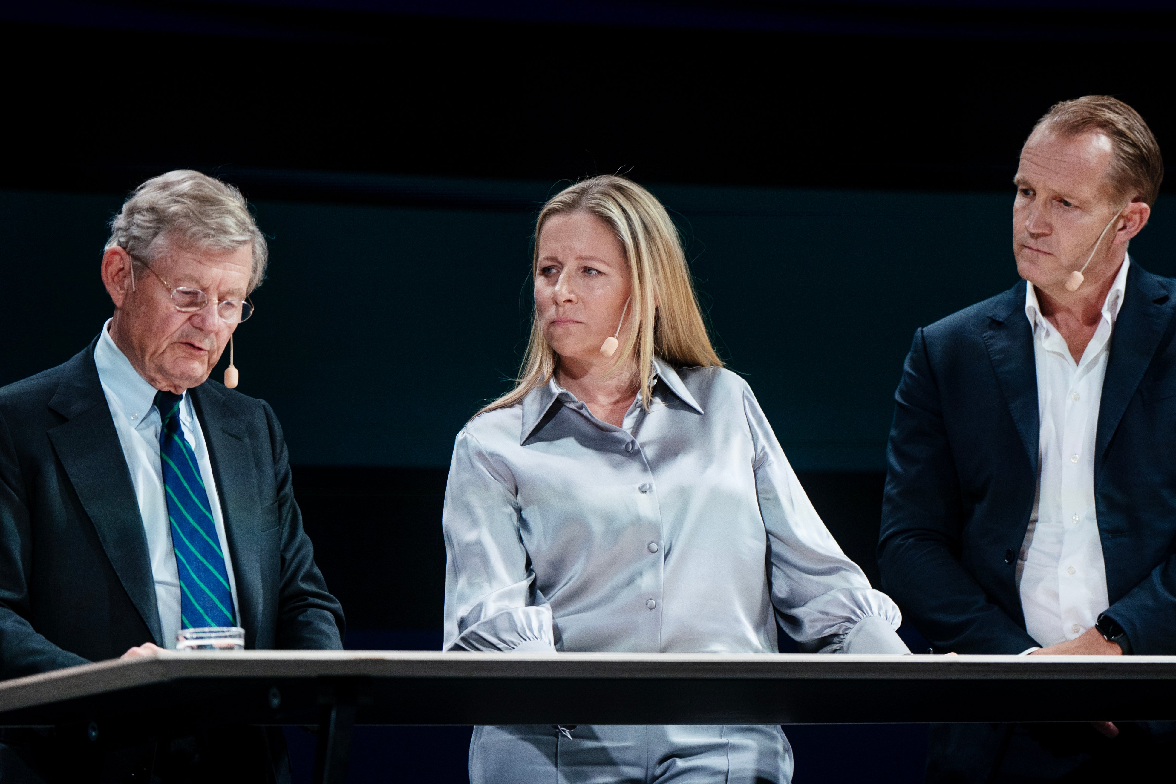 Tre personer sitter vid ett bord under en paneldiskussion på ett näringslivsevent.