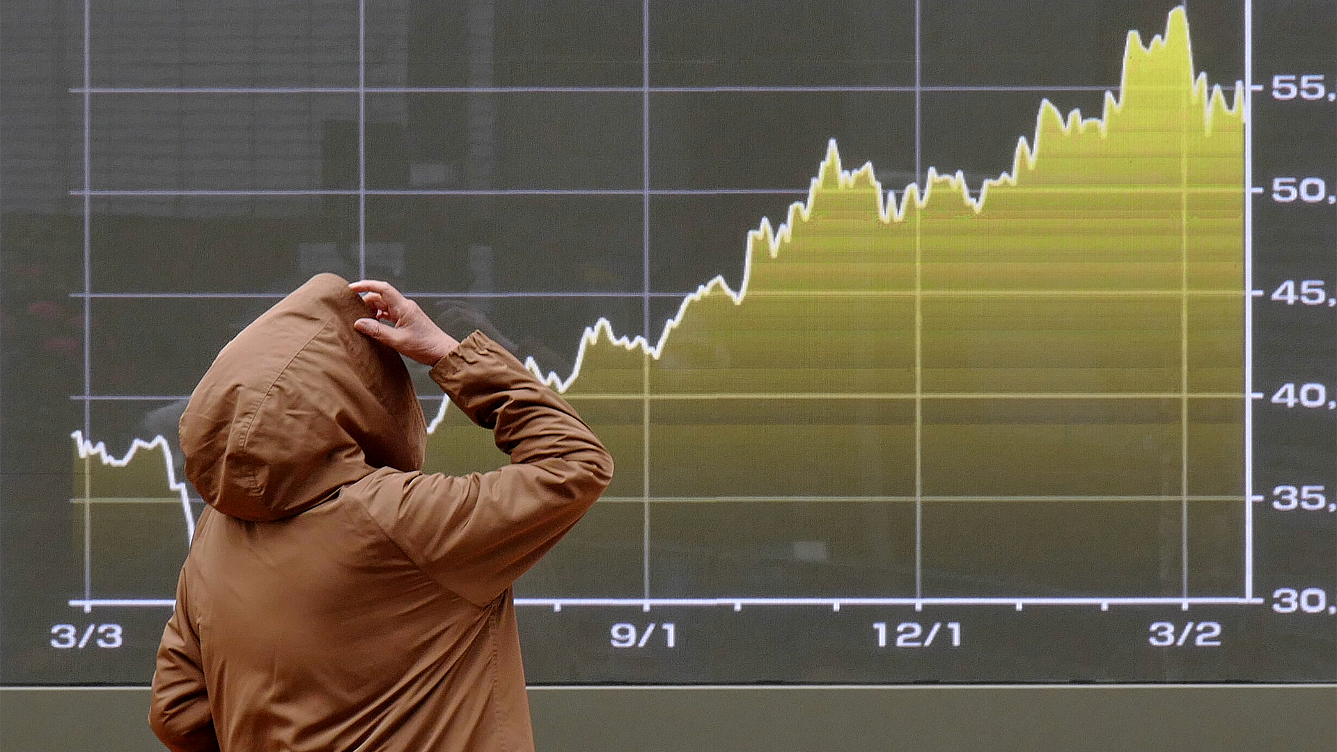 Person tittar på en stigande aktiekurs på en finansiell graf