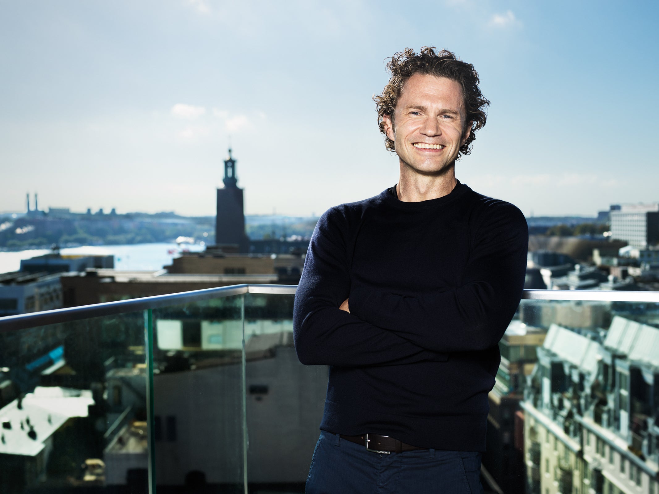 Man står på en balkong högt upp med stadsvy i bakgrunden