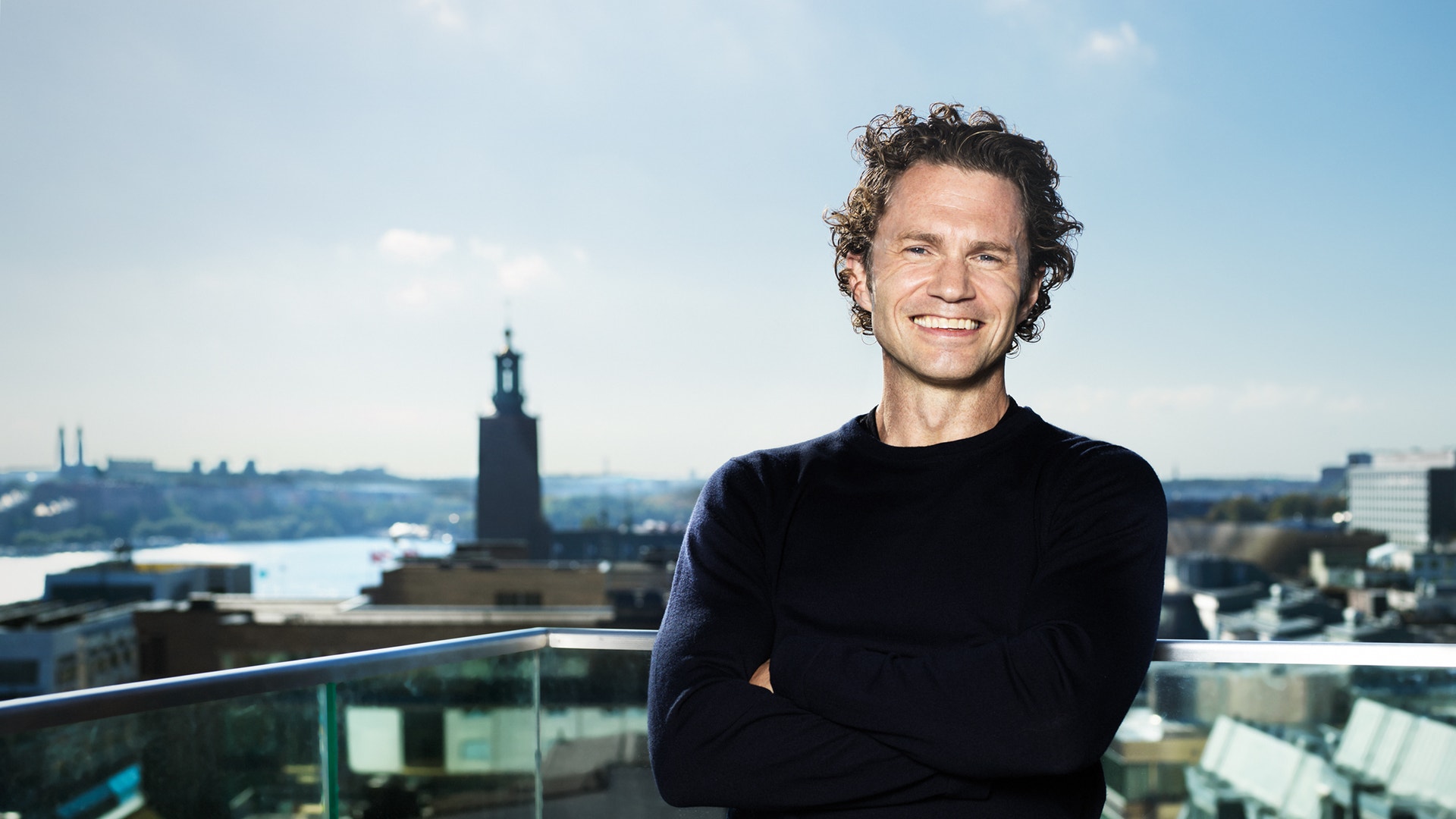 Man står på en balkong högt upp med stadsvy i bakgrunden