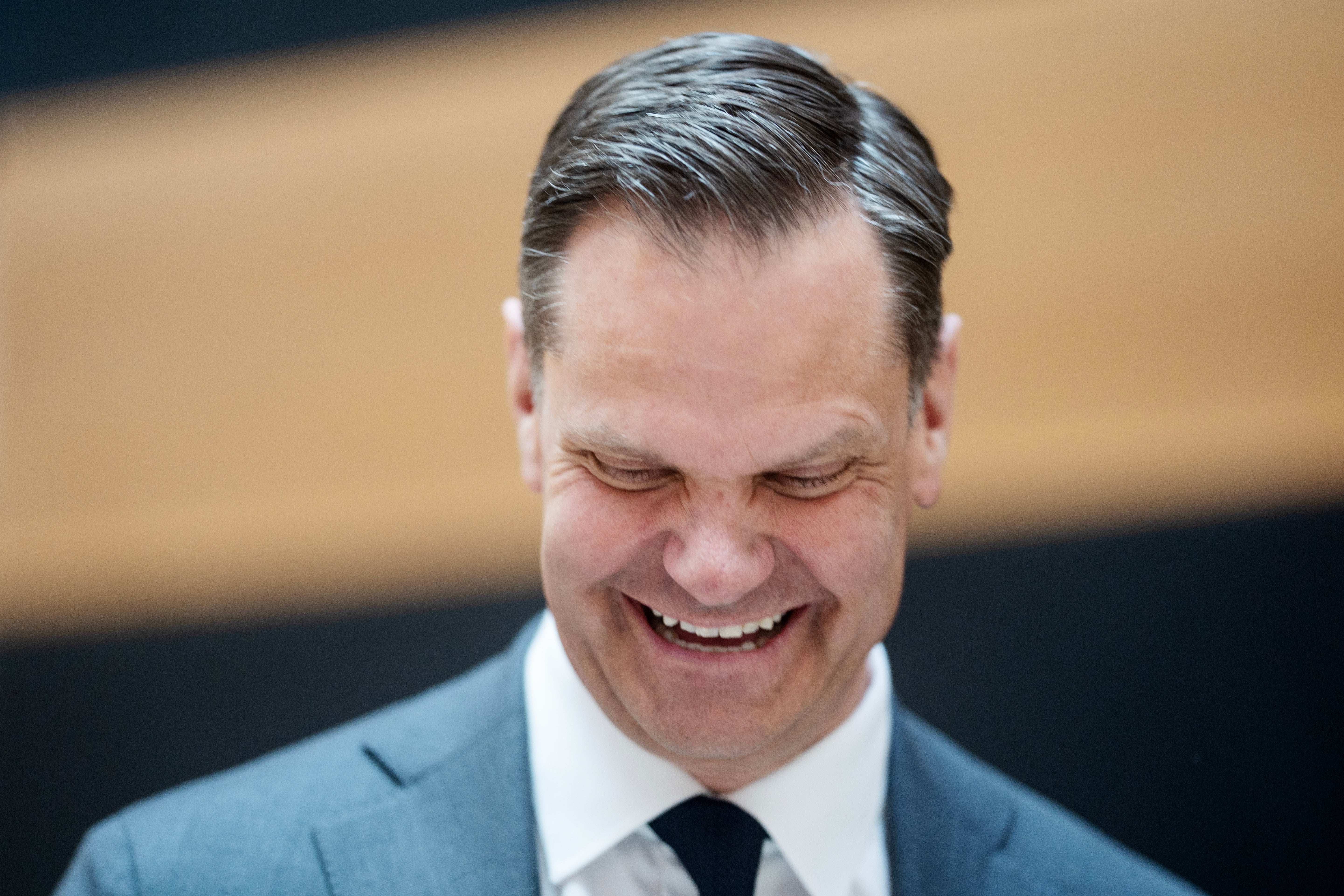 Porträtt av en man i kostym och slips som ler mot kameran.