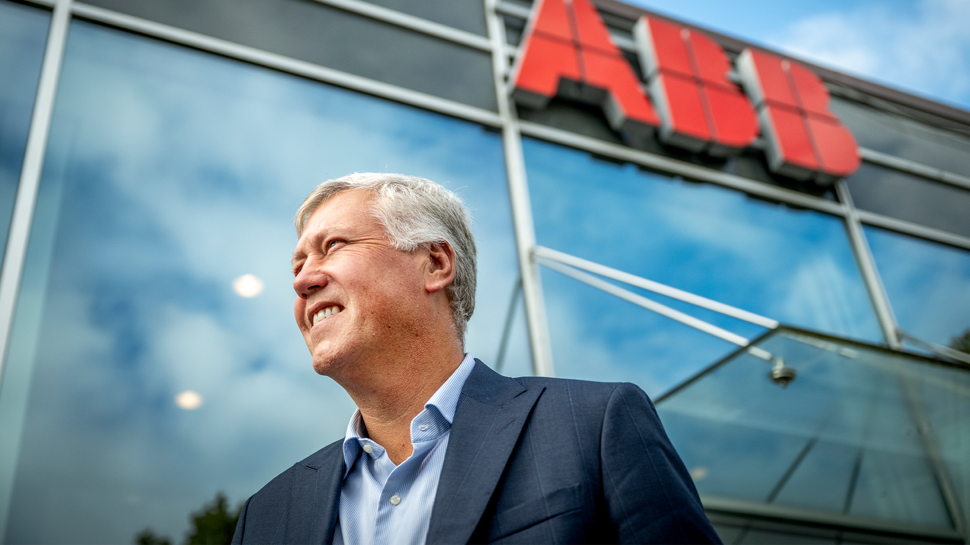 Man i kostym framför ABB-byggnad