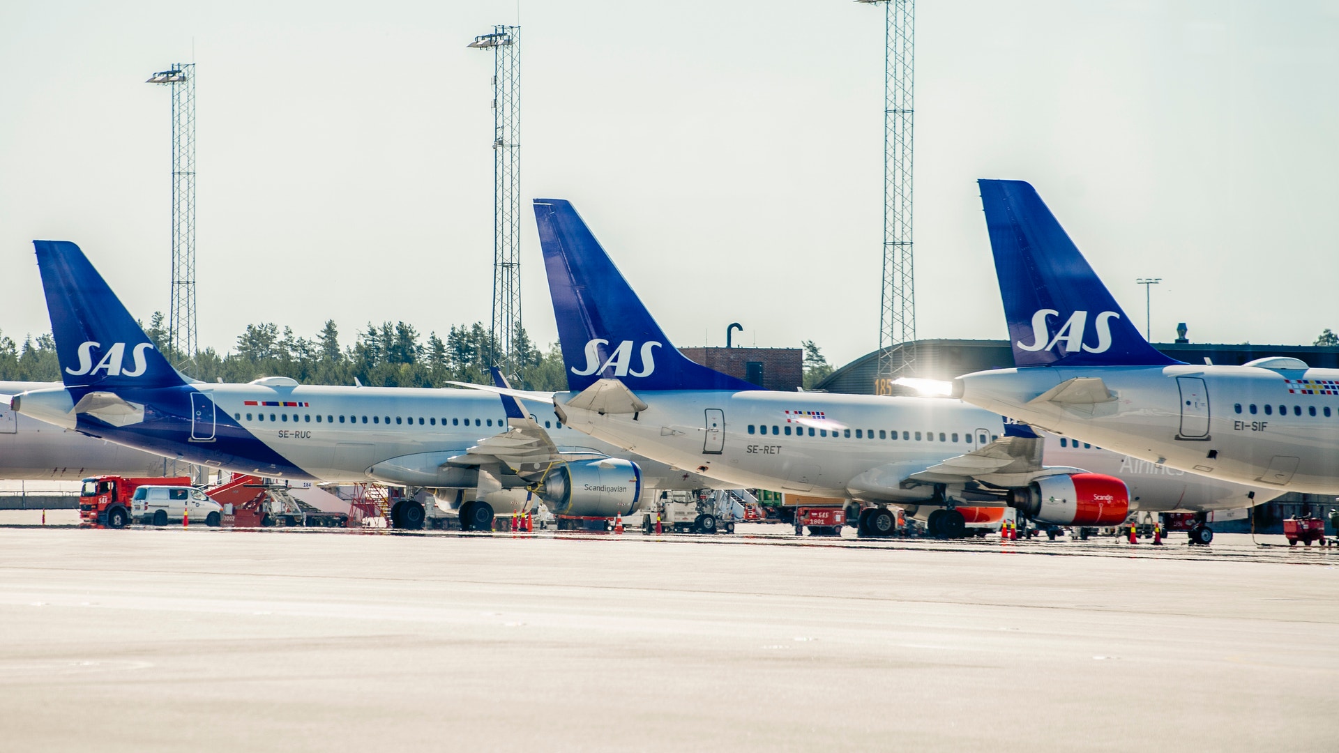 Tre SAS-flygplan parkerade på en flygplatsapron