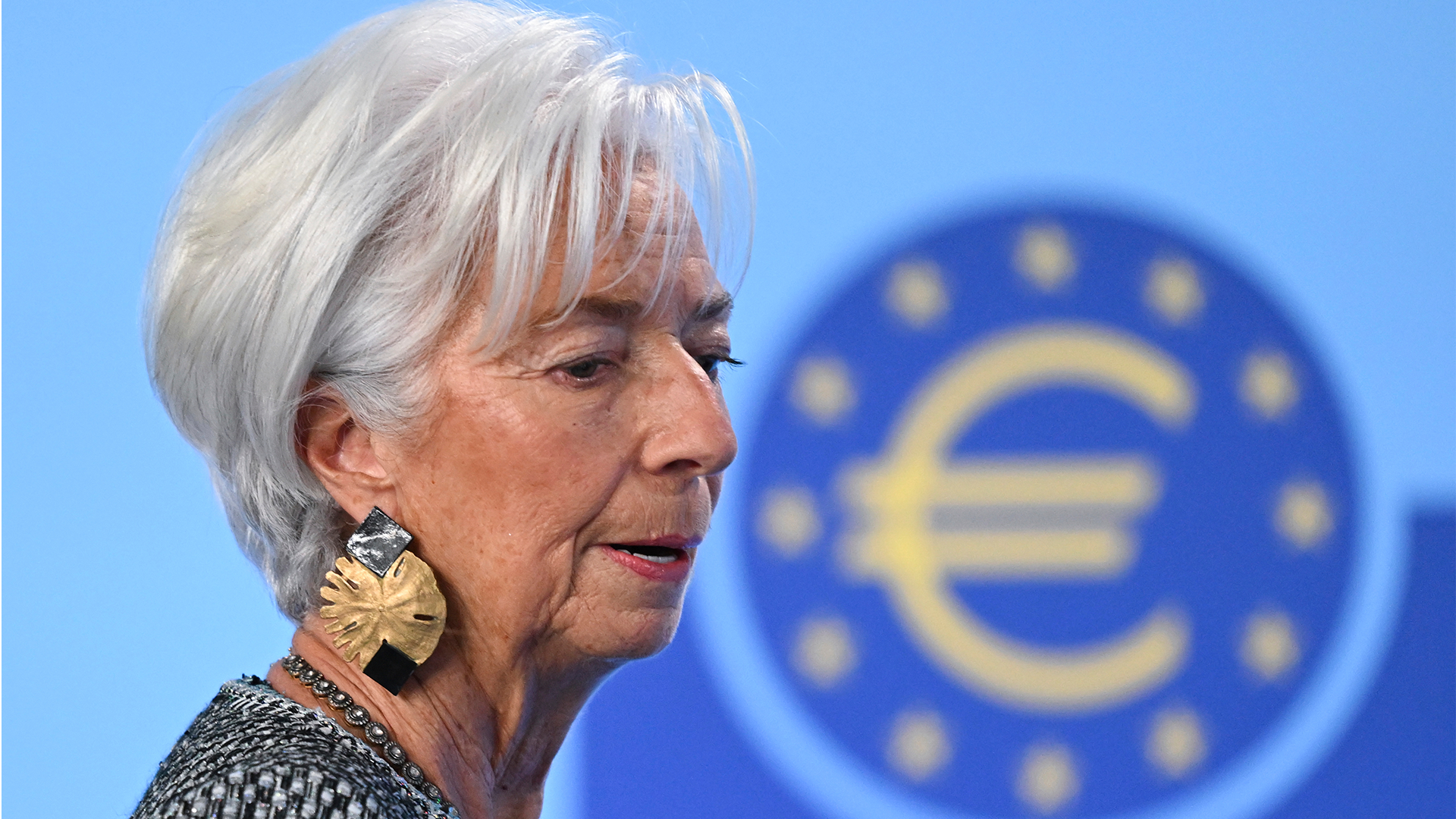 Porträtt av en kvinna i profil framför ECB-logotypen på blå bakgrund.