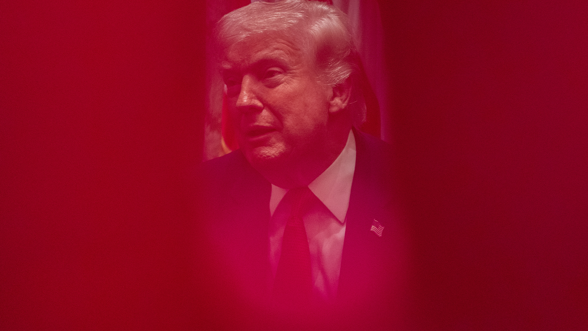 Porträtt av man i kostym och slips mot rosa bakgrund