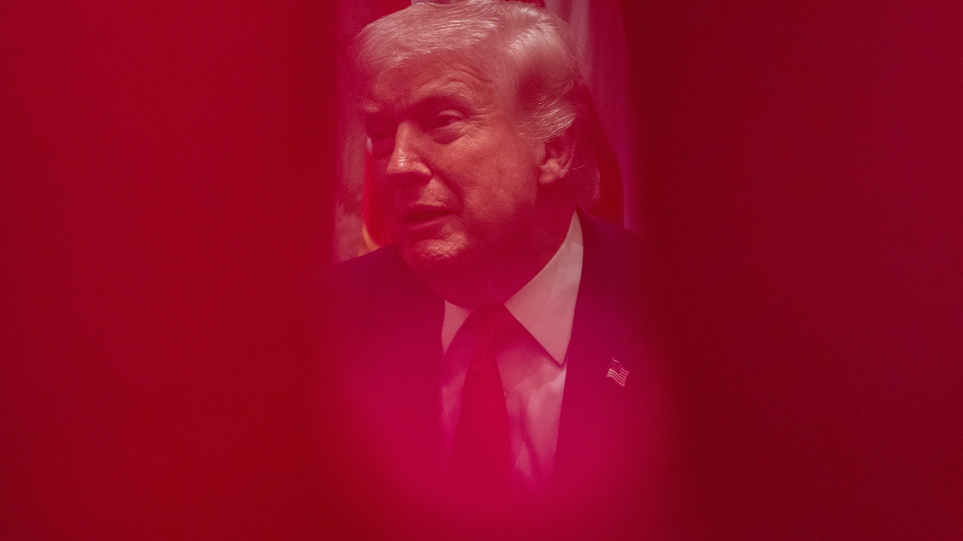 Porträtt av man i kostym och slips mot rosa bakgrund