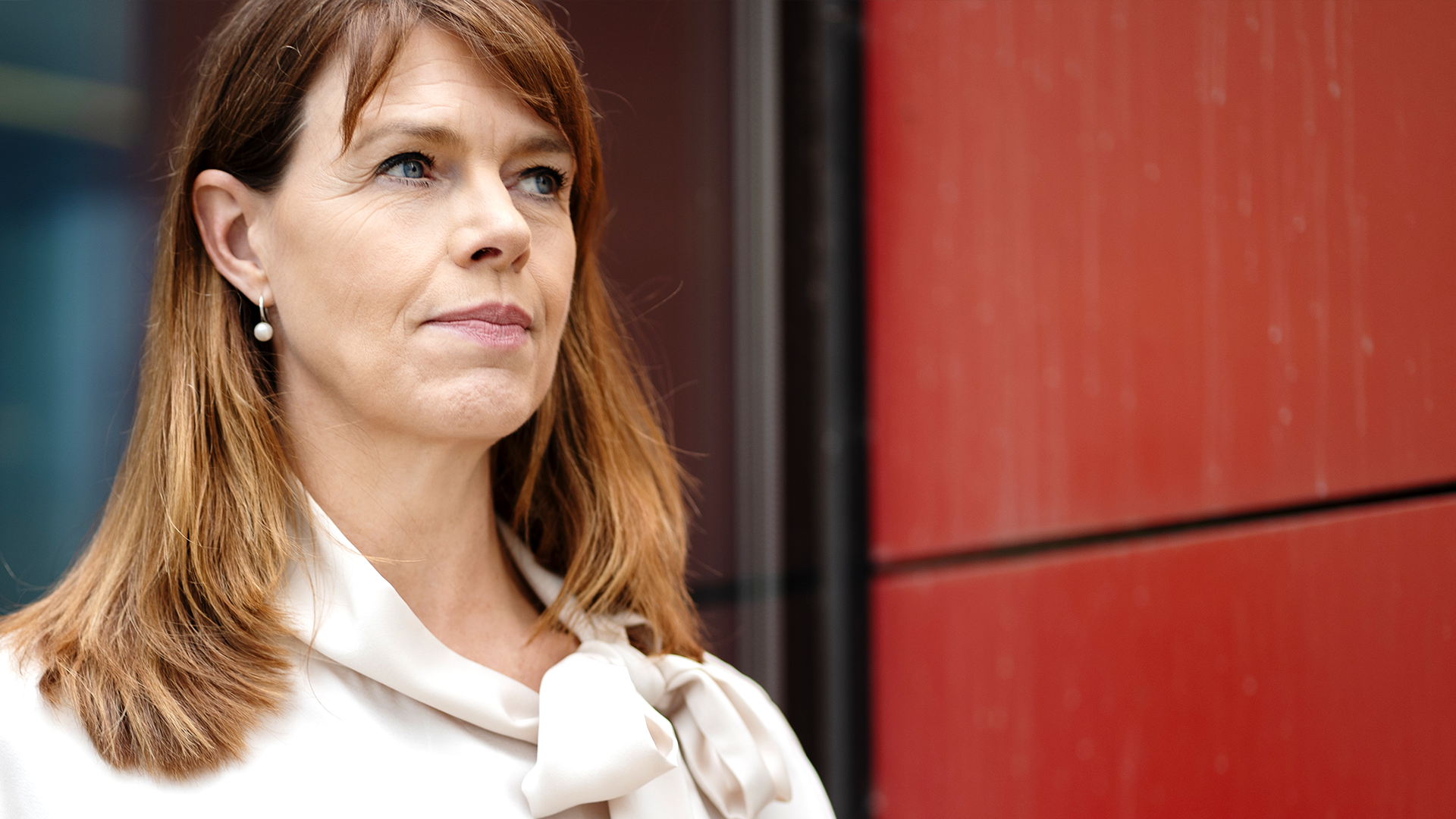 Linda Pålsson ser bekymrad ut. Hon står framför en röd vägg.