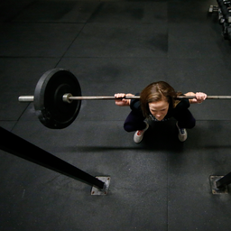 Person lyfter skivstång i ett gym