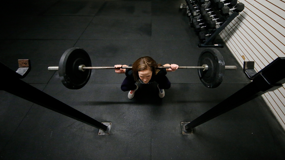 Person lyfter skivstång i ett gym