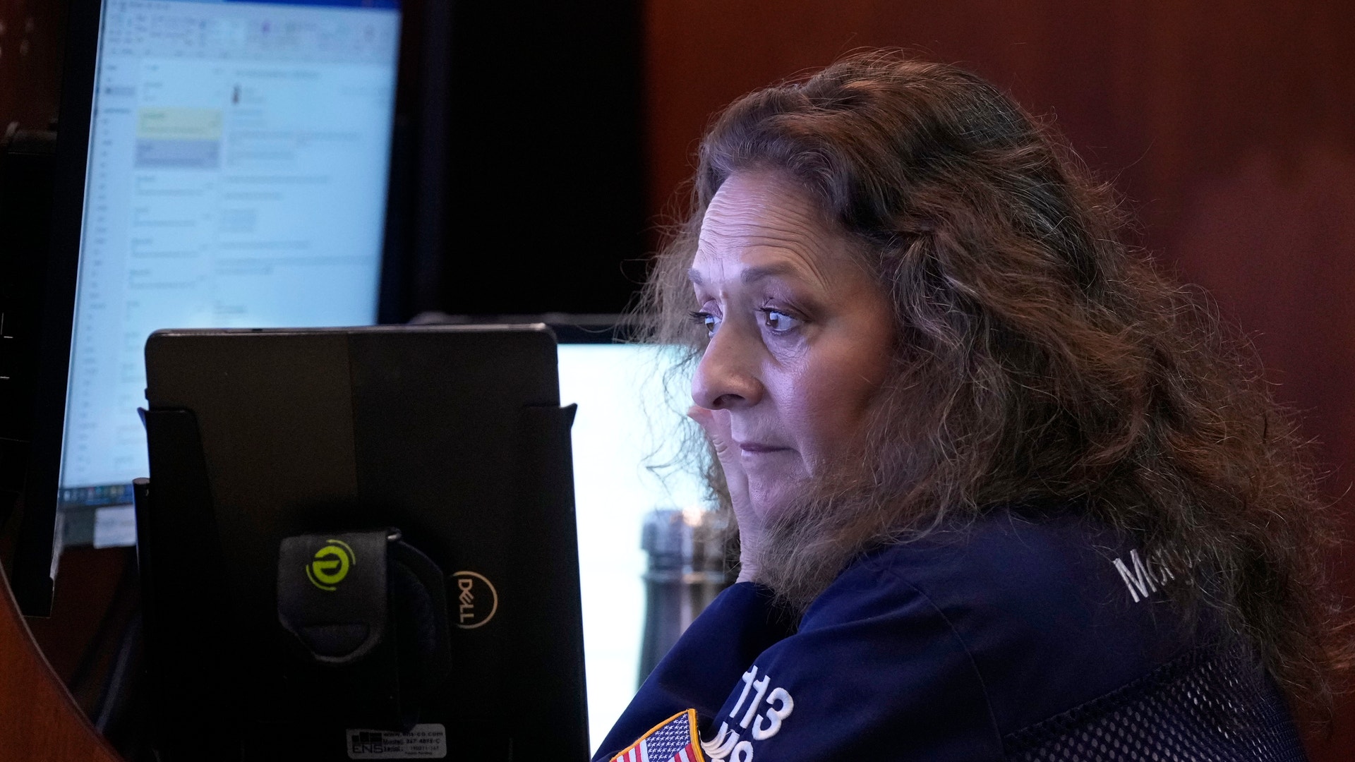 Person sitter vid ett skrivbord med datorutrustning och inspelningsutrustning.