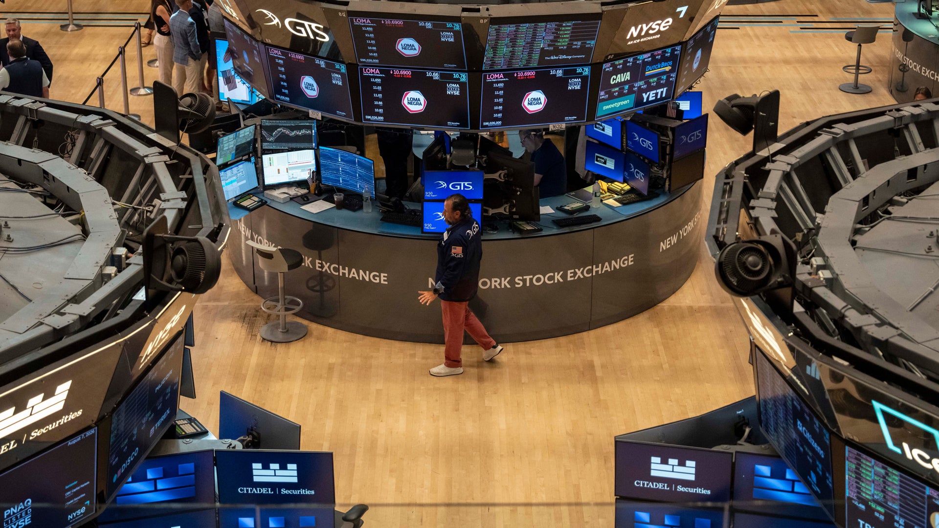 Flygfotografi av New York Stock Exchange handelsgolv med handlare och dataskärmar.