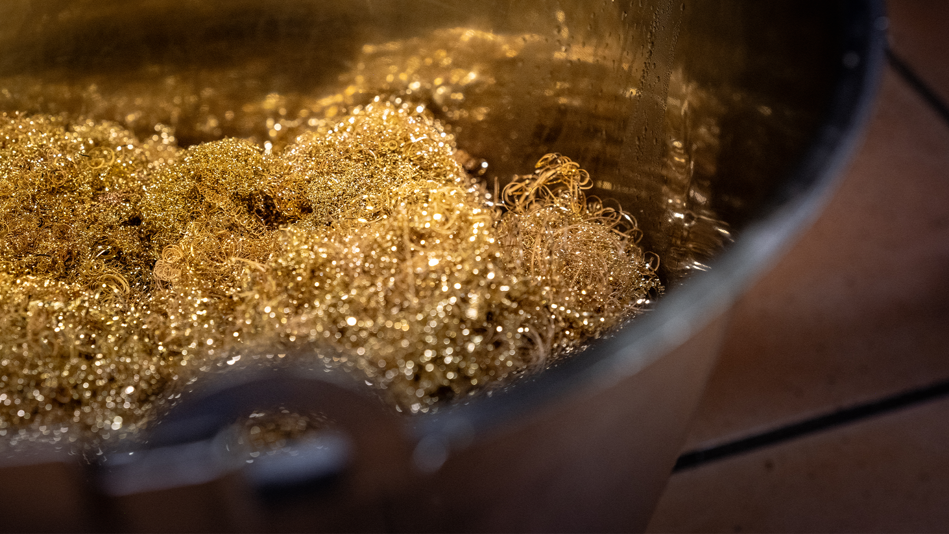 Närbild av guldglitter som skimrar i en behållare