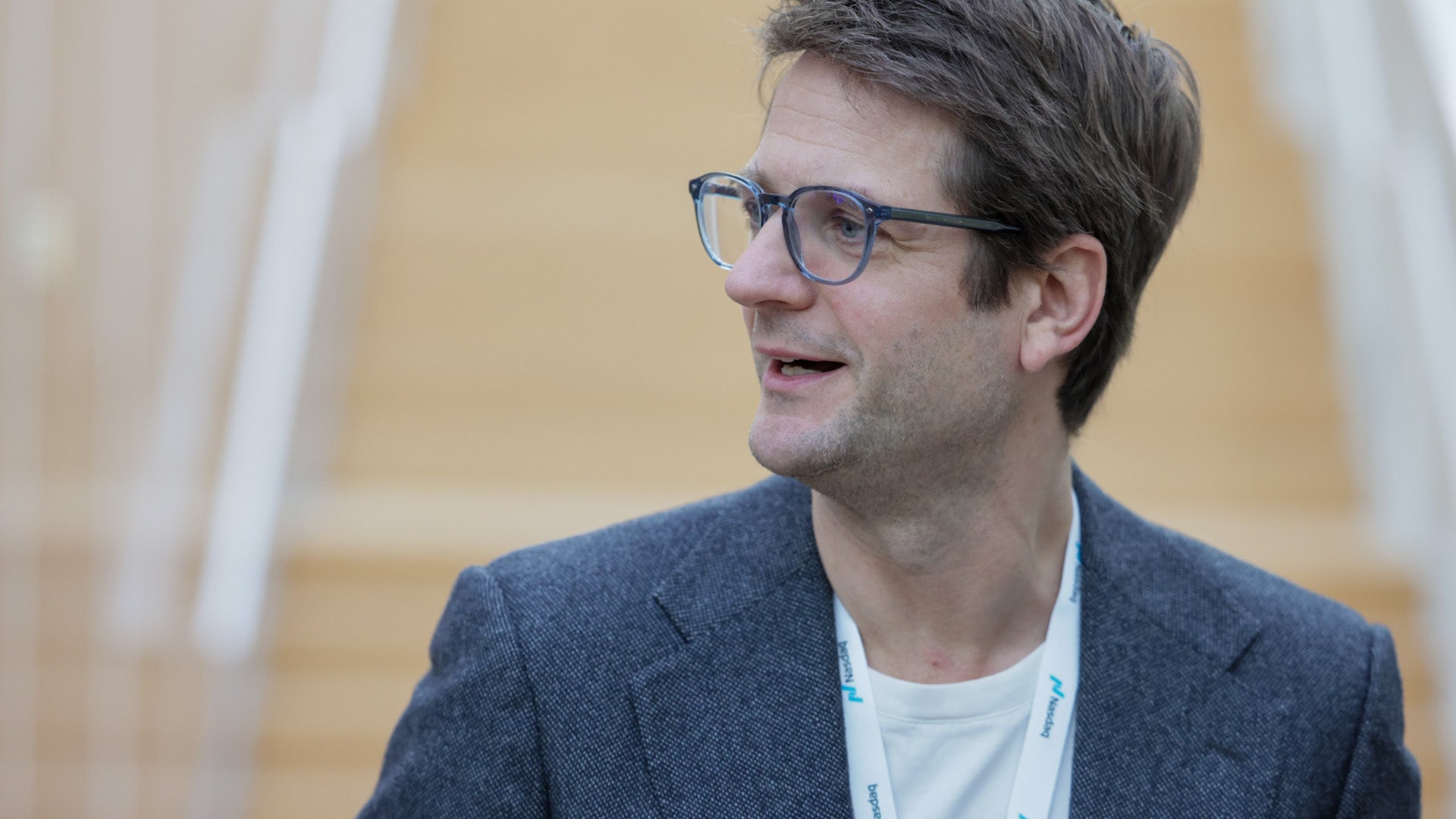 Sebastian Siemiatkowski med glasögon i blå kavaj under ett samtal eller presentation