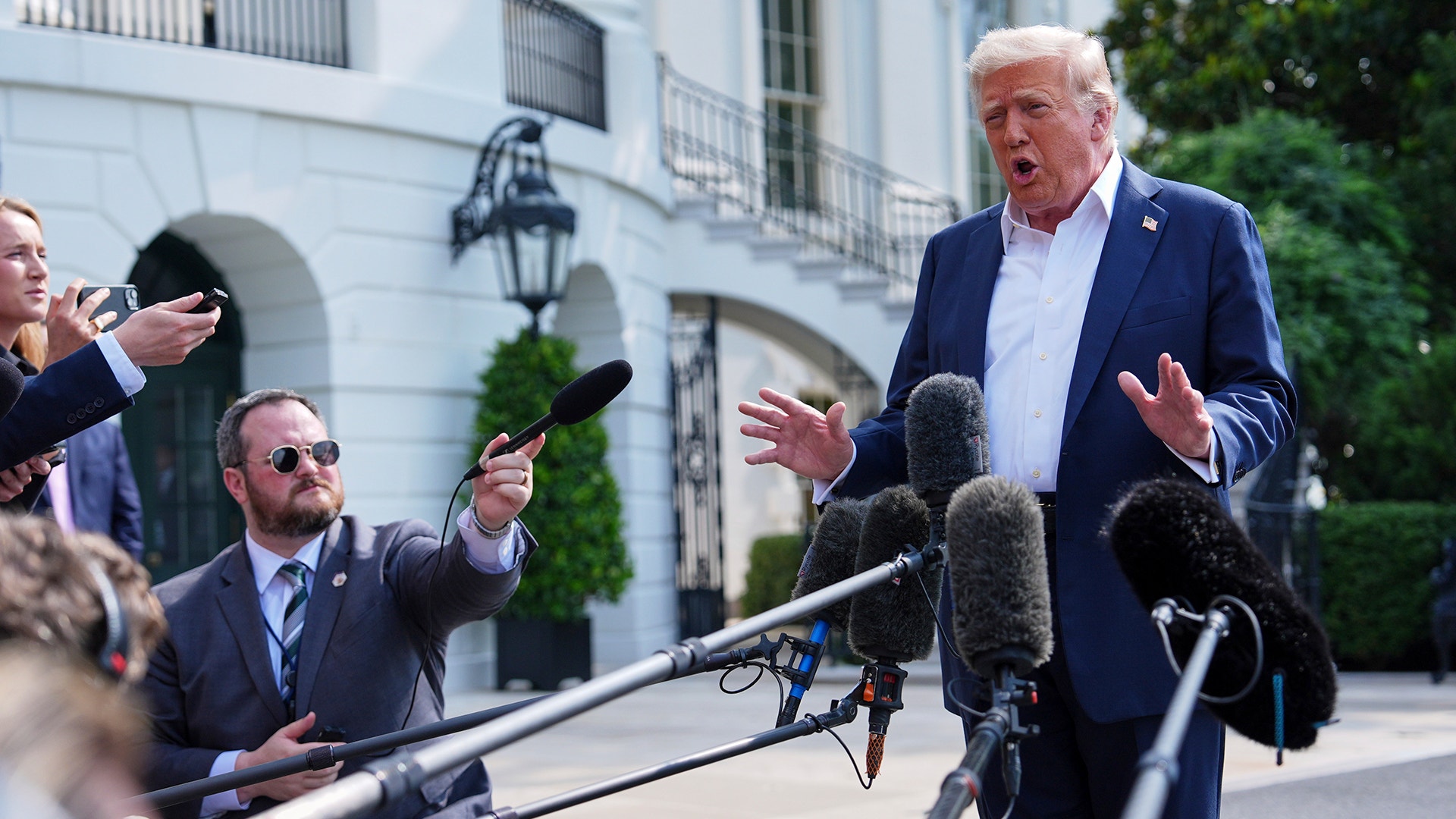 Donald Trump frågas ut av flertalet reportrar utanför Vita huset i Washington.