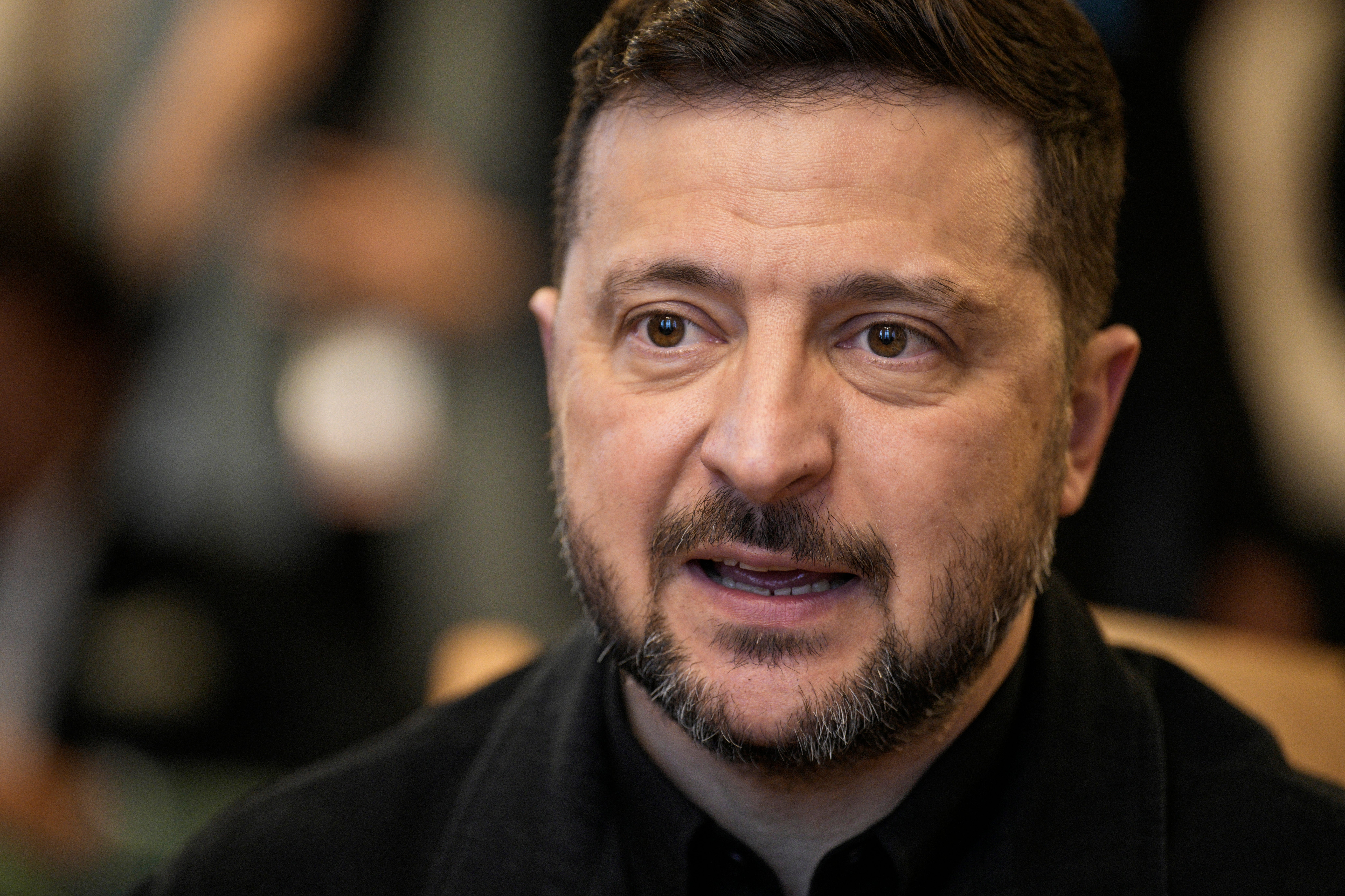 Porträtt av en man med skägg, iklädd mörk klädsel.