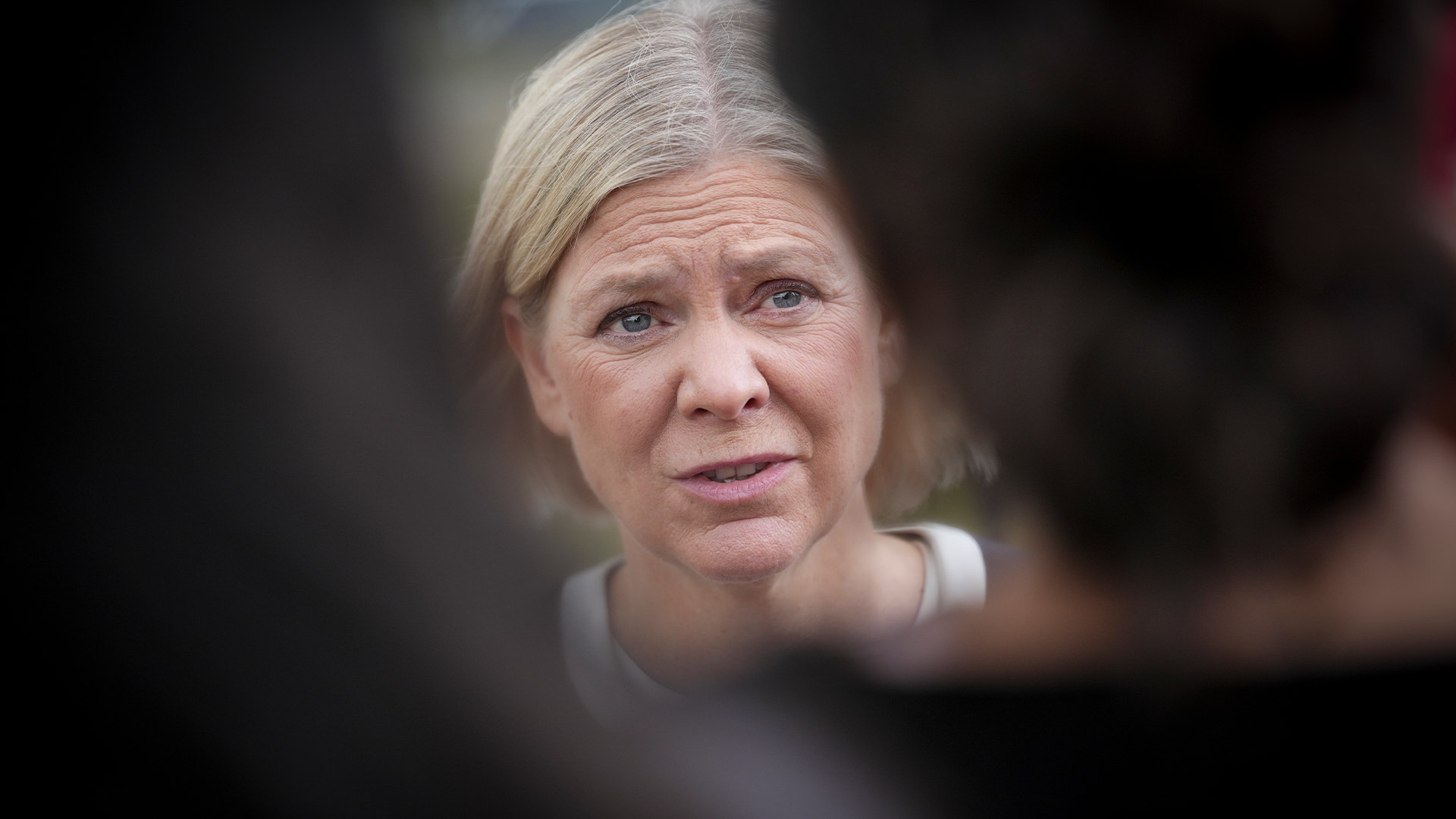 Porträtt av en kvinna med grått hår som tittar mot kameran.