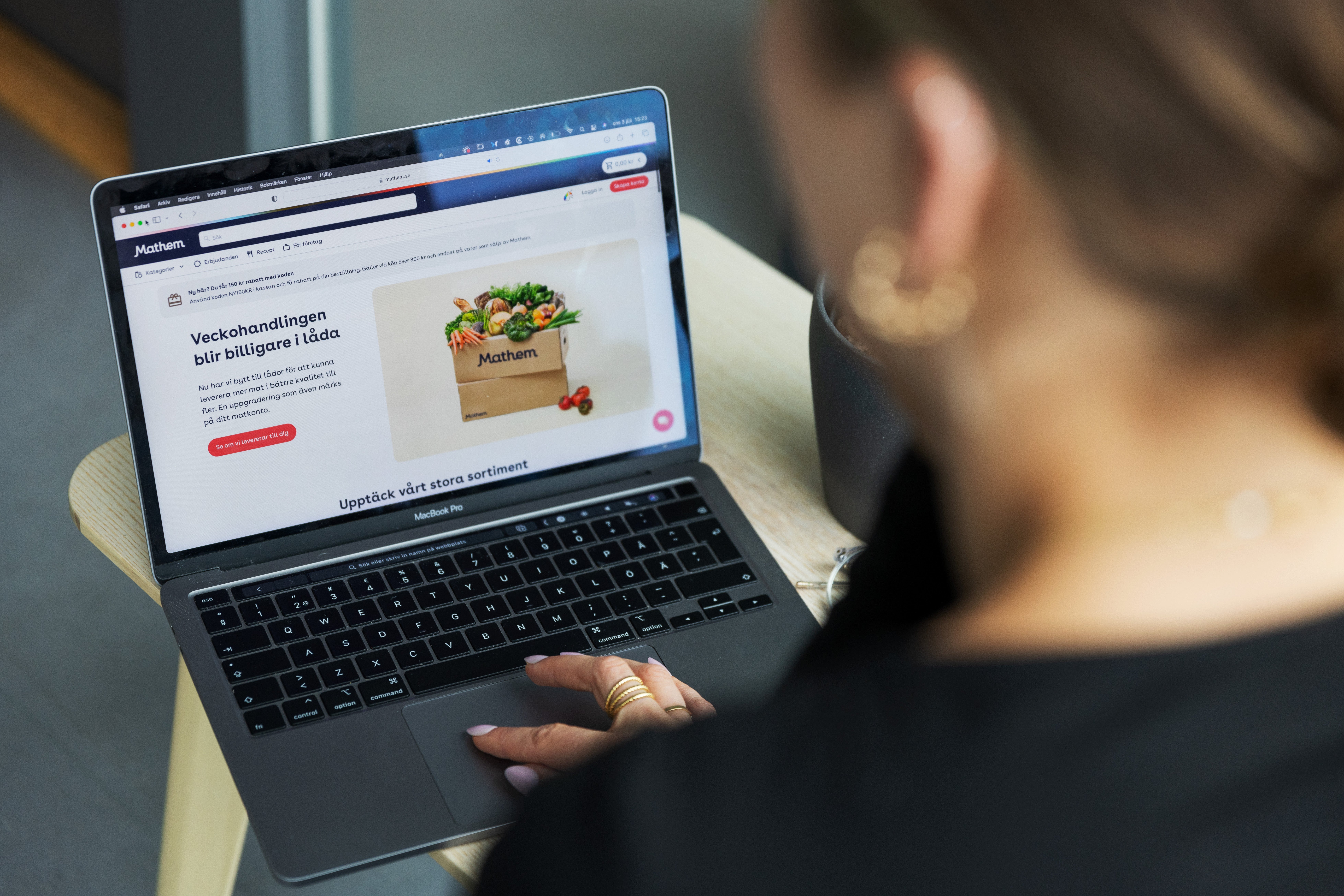 En person använder en laptop och tittar på en webbsida som visar grönsaker i en papperskasse.