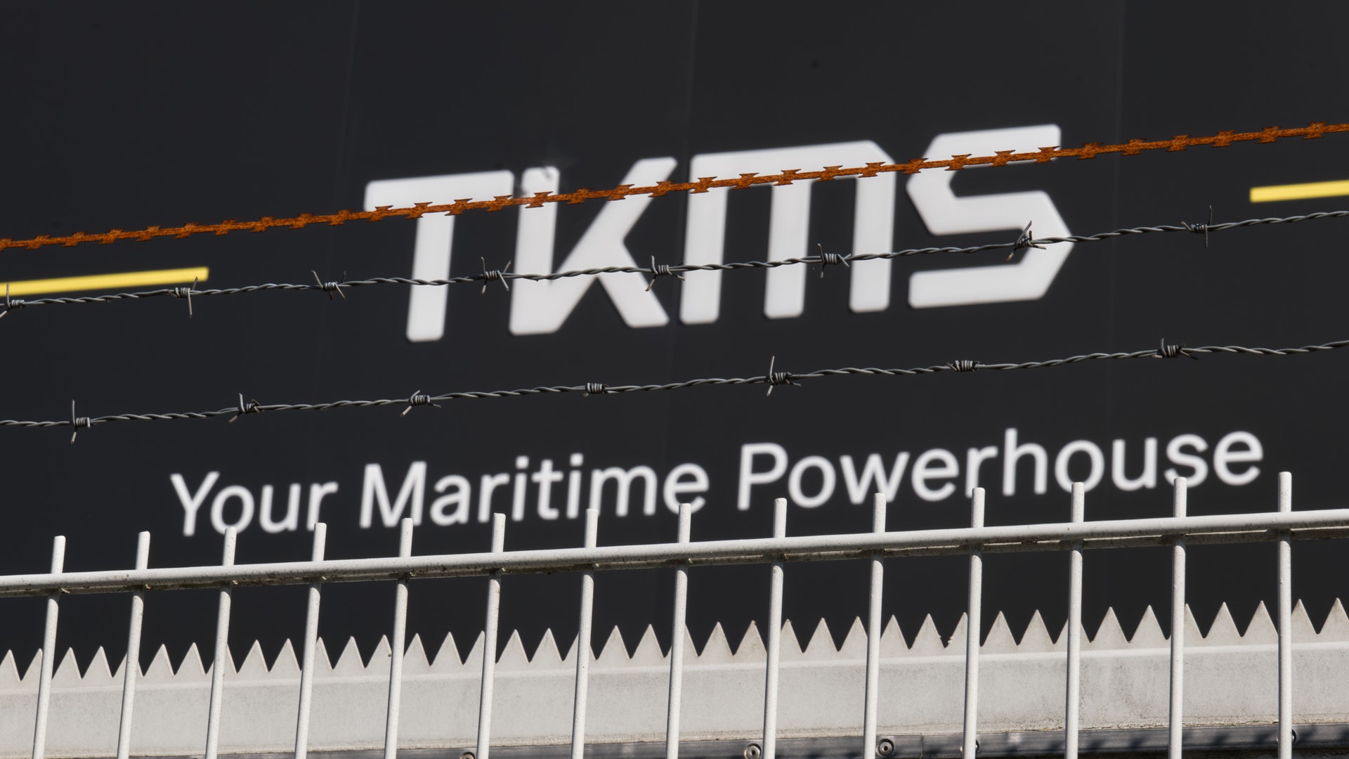 KMS-skylt med texten 'Your Maritime Powerhouse' och dekorativ grässtrand