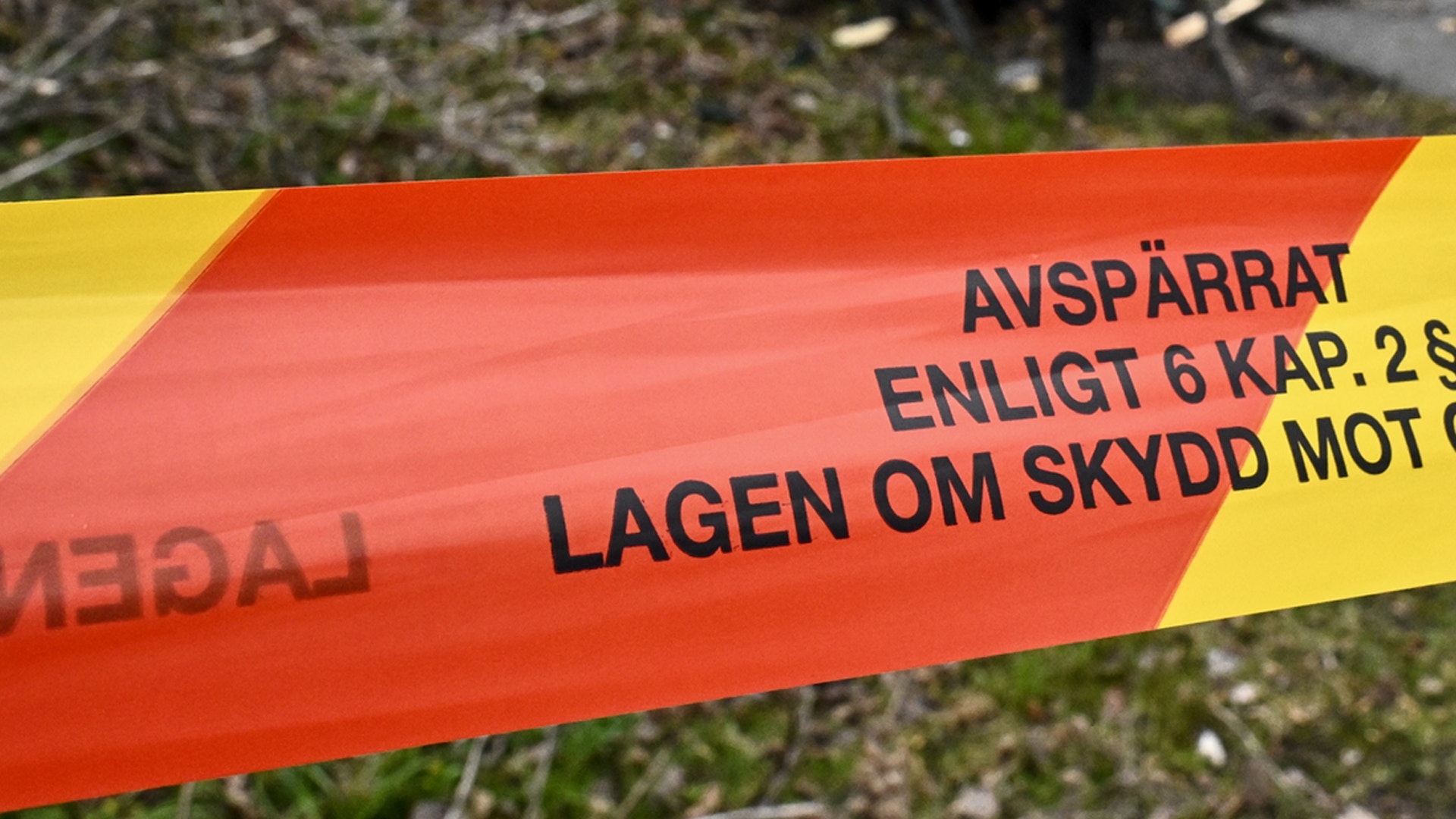 Rött och gult avspärrningsband med svensk text som varnar om att området är avspärrat