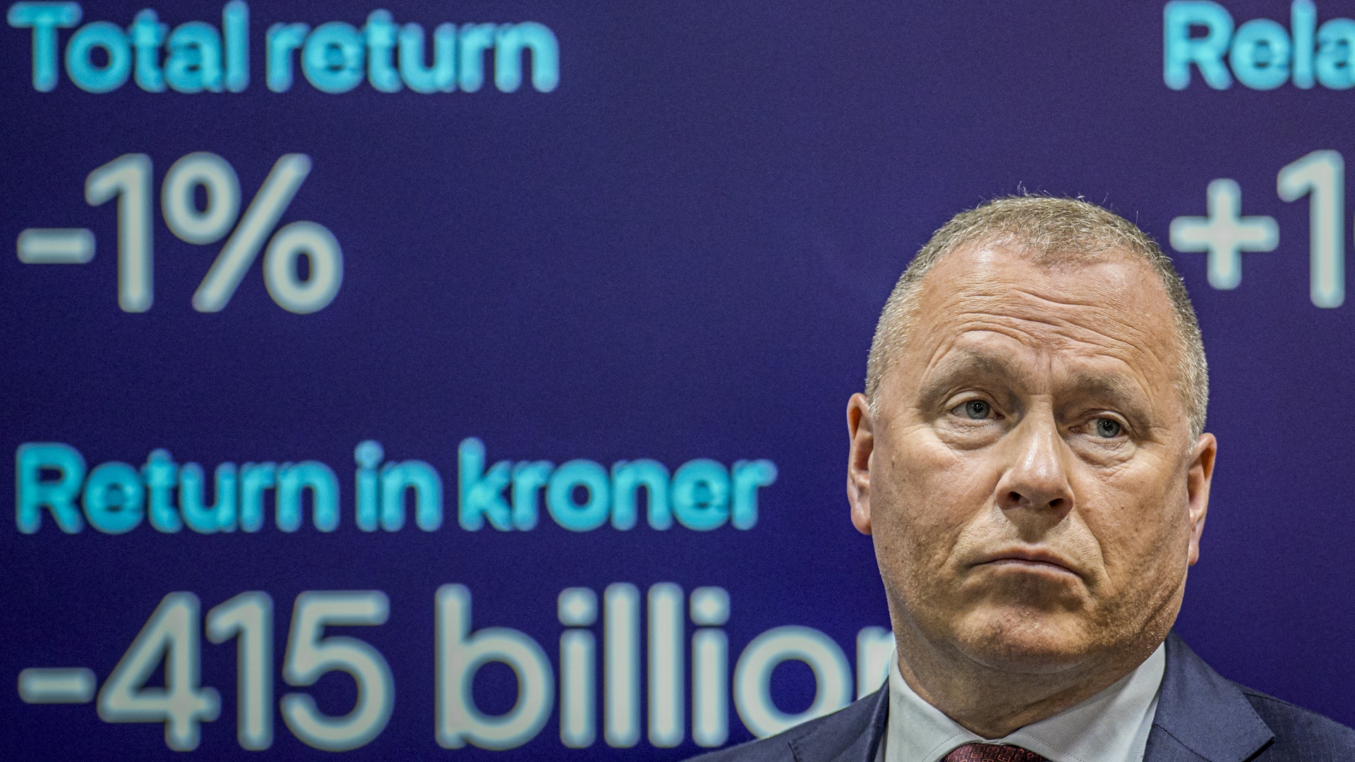 Man i kostym framför finansiell data och avkastningsstatistik