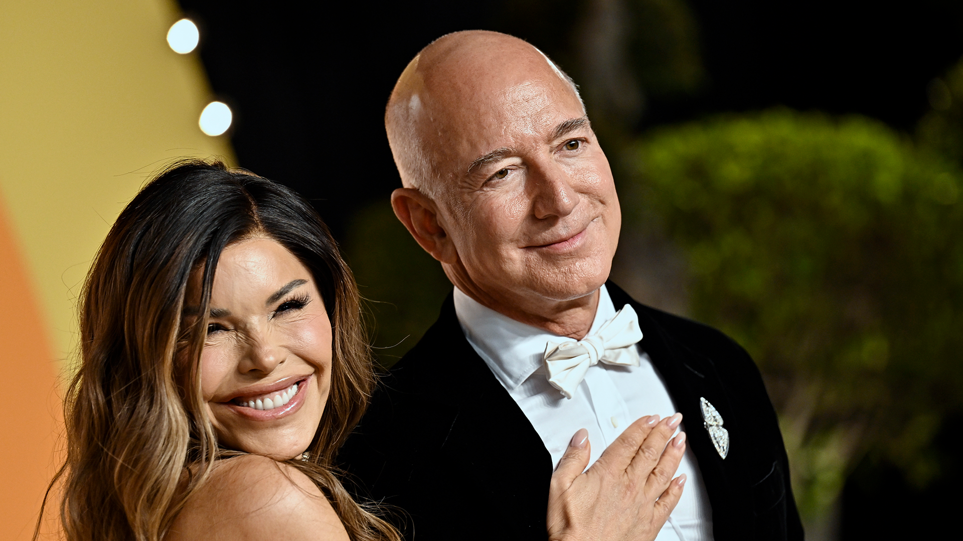Jeff Bezos och Lauren Sánches står och ler till kamerorna på röda mattan.