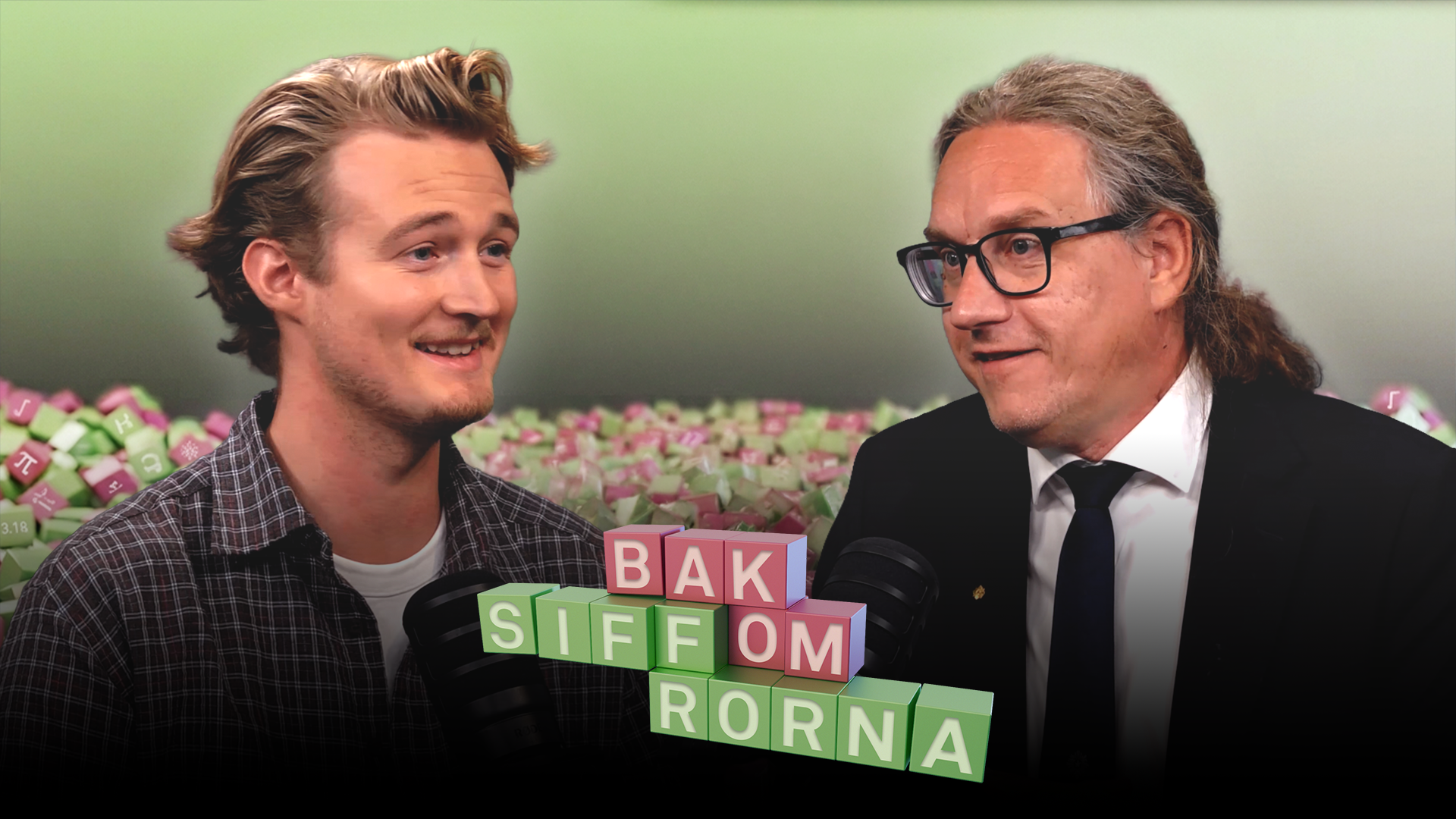 Två leende män i samtal framför en vägg av färgglada klossar. Mellan dem står texten "Bak siffrorna".
