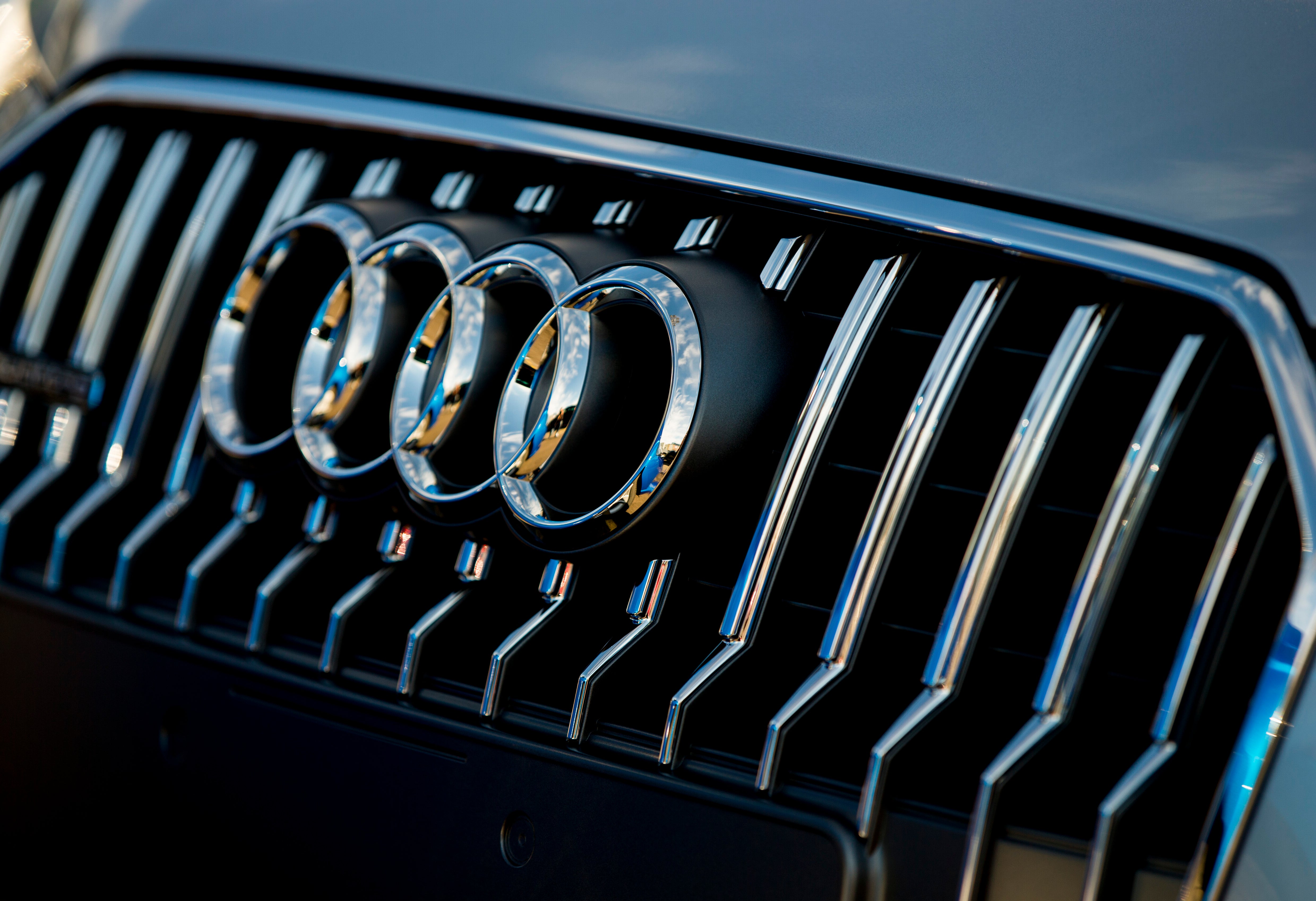 Närbild på Audis logotyp med fyra krom-ringar på bilens grill