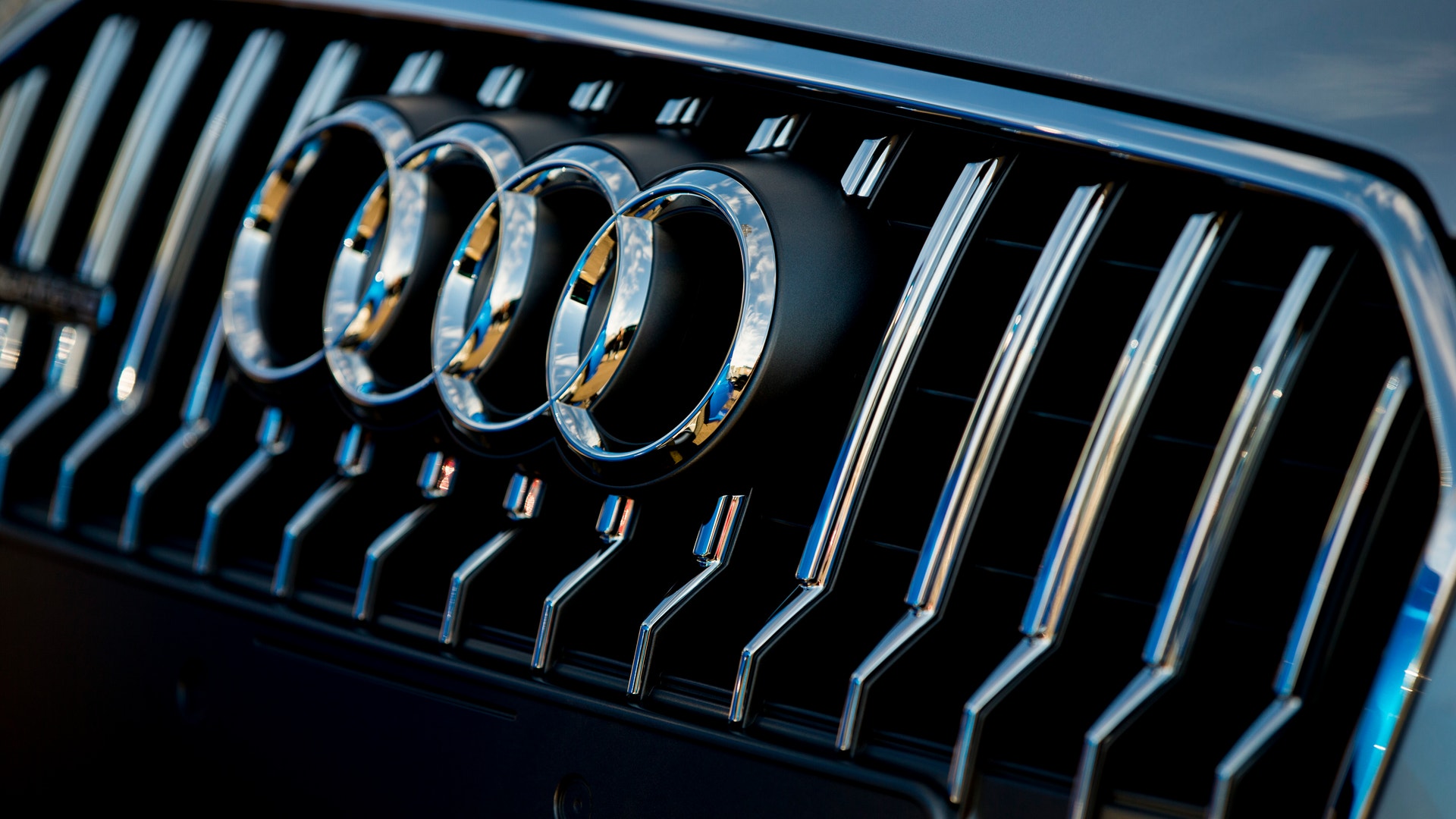 Närbild på Audis logotyp med fyra krom-ringar på bilens grill