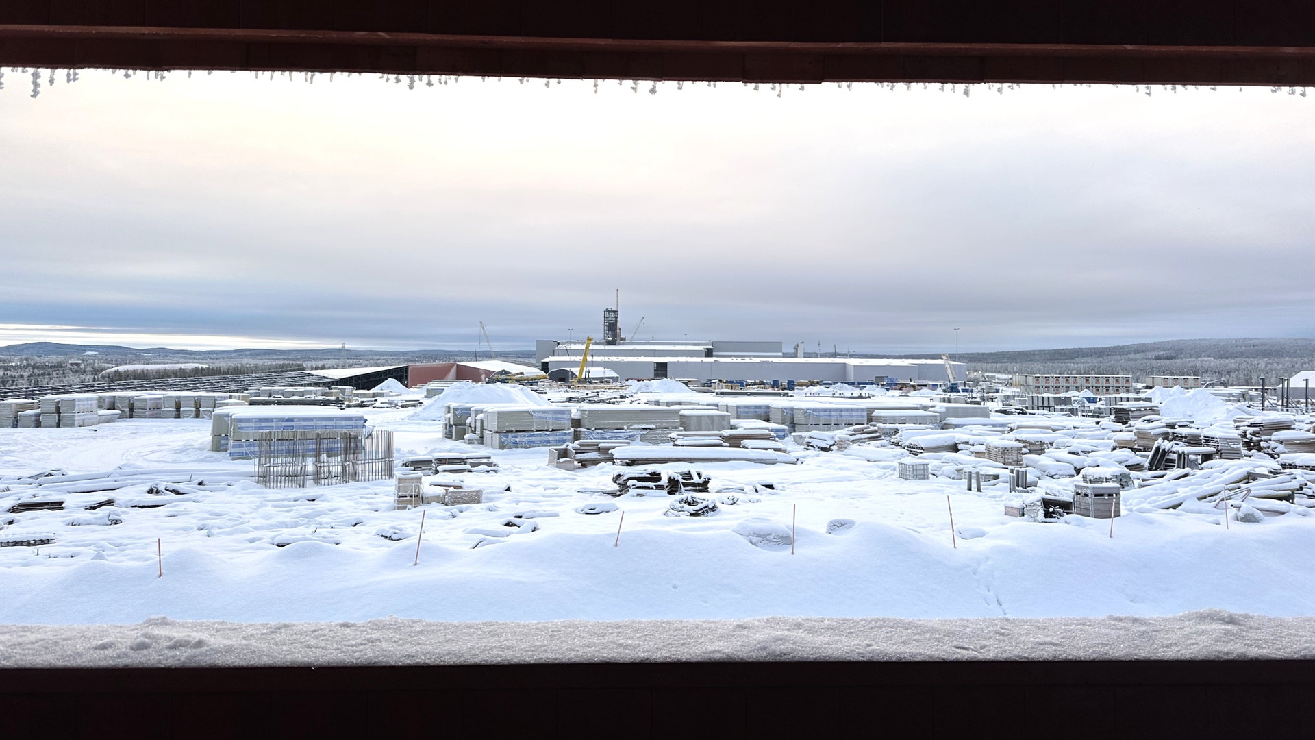 Snöigt industriområde med fabriker och byggnader under vintern