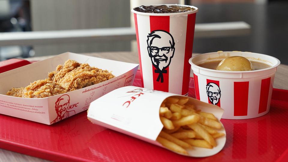 KFC-måltid med stekt kyckling, pommes frites och dryck i röd och vit förpackning