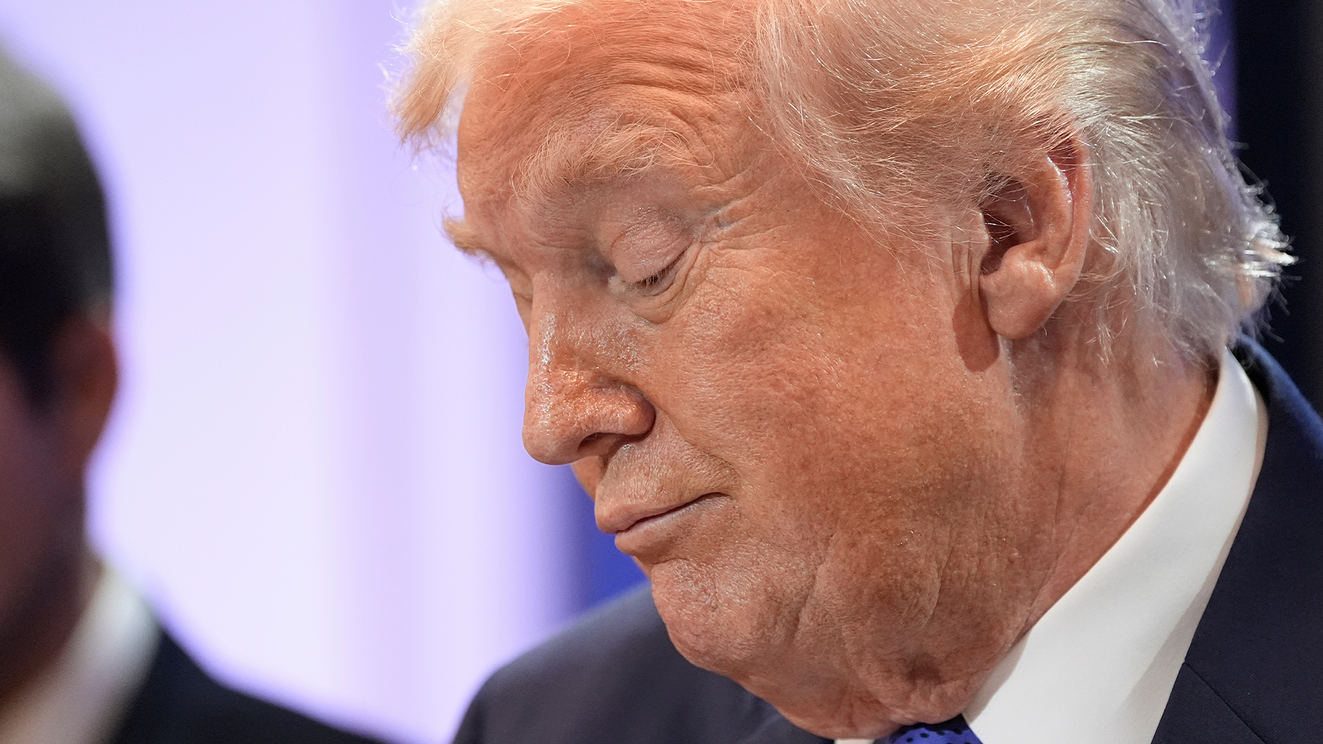 Profilbild av Donald Trump i mörk kostym och blå slips.