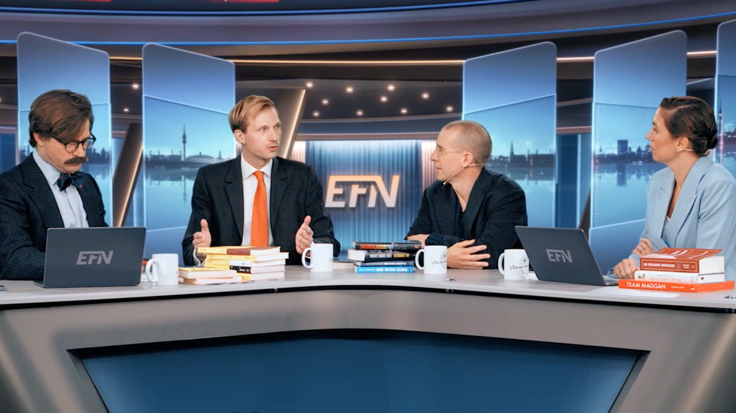 Fyra personer sitter vid ett bord i en tv-studio och samtalar, med böcker och kaffekoppar framför sig.