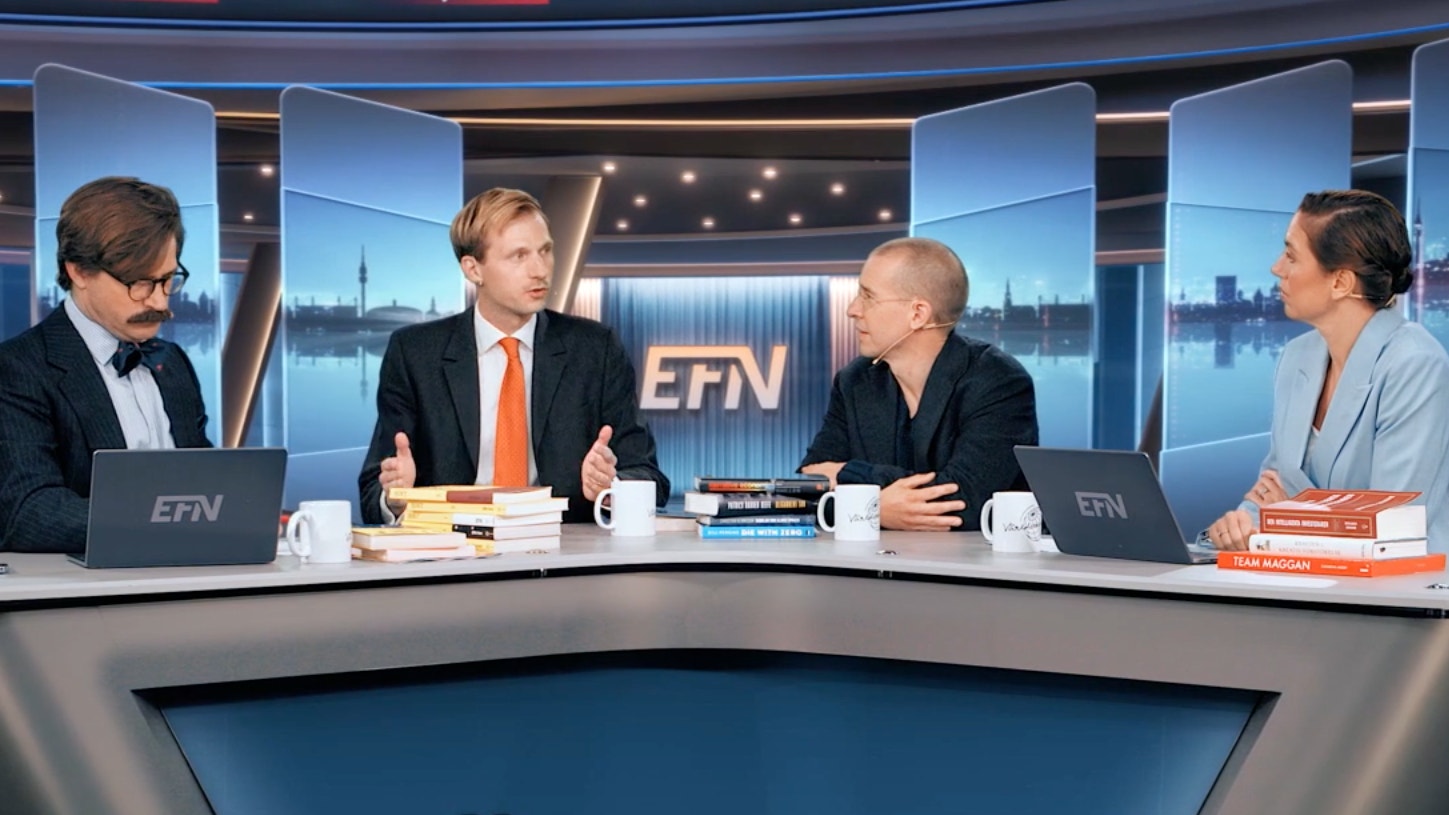 Fyra personer sitter vid ett bord i en tv-studio och samtalar, med böcker och kaffekoppar framför sig.