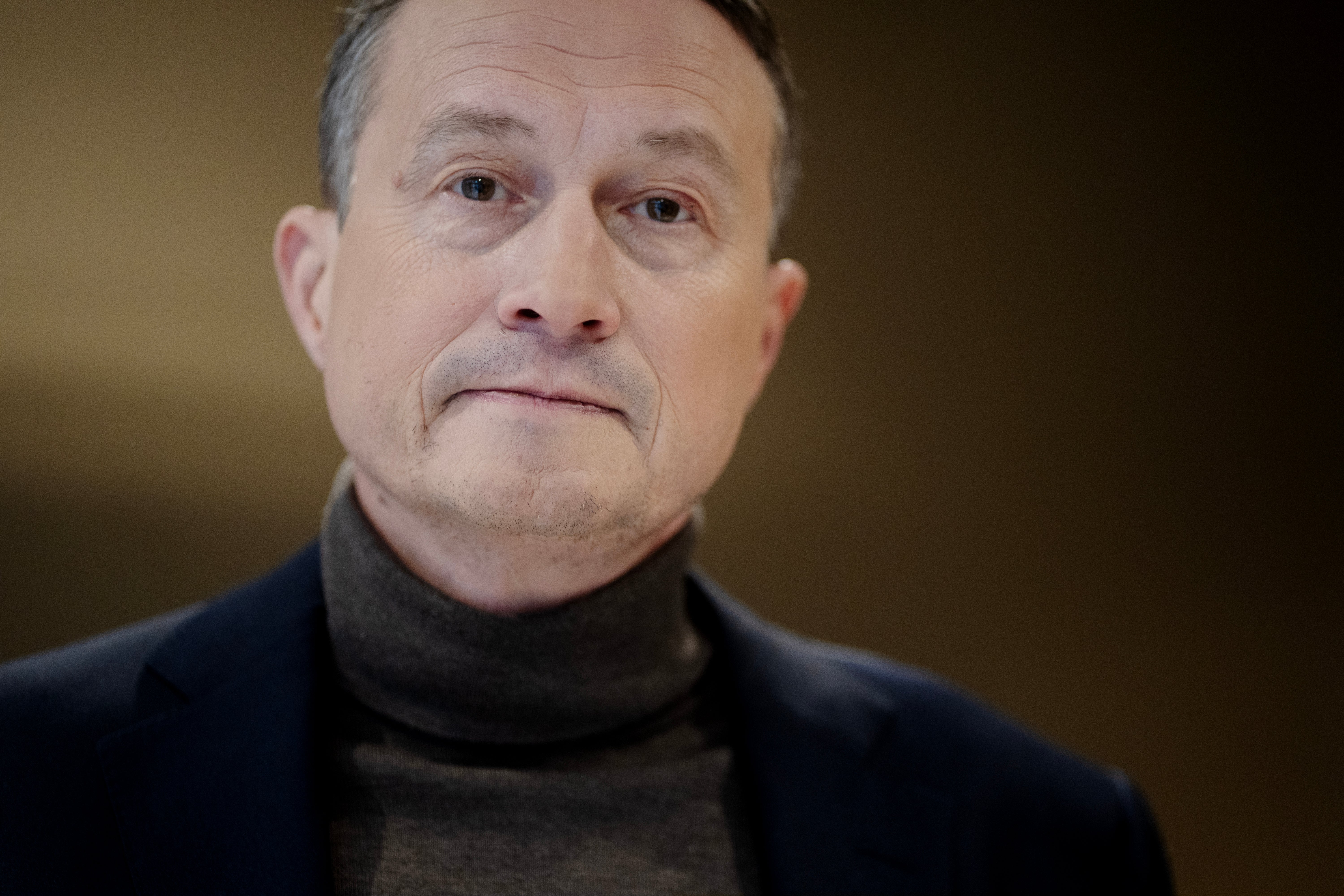 Porträtt av en man med grått hår och mörk tröja